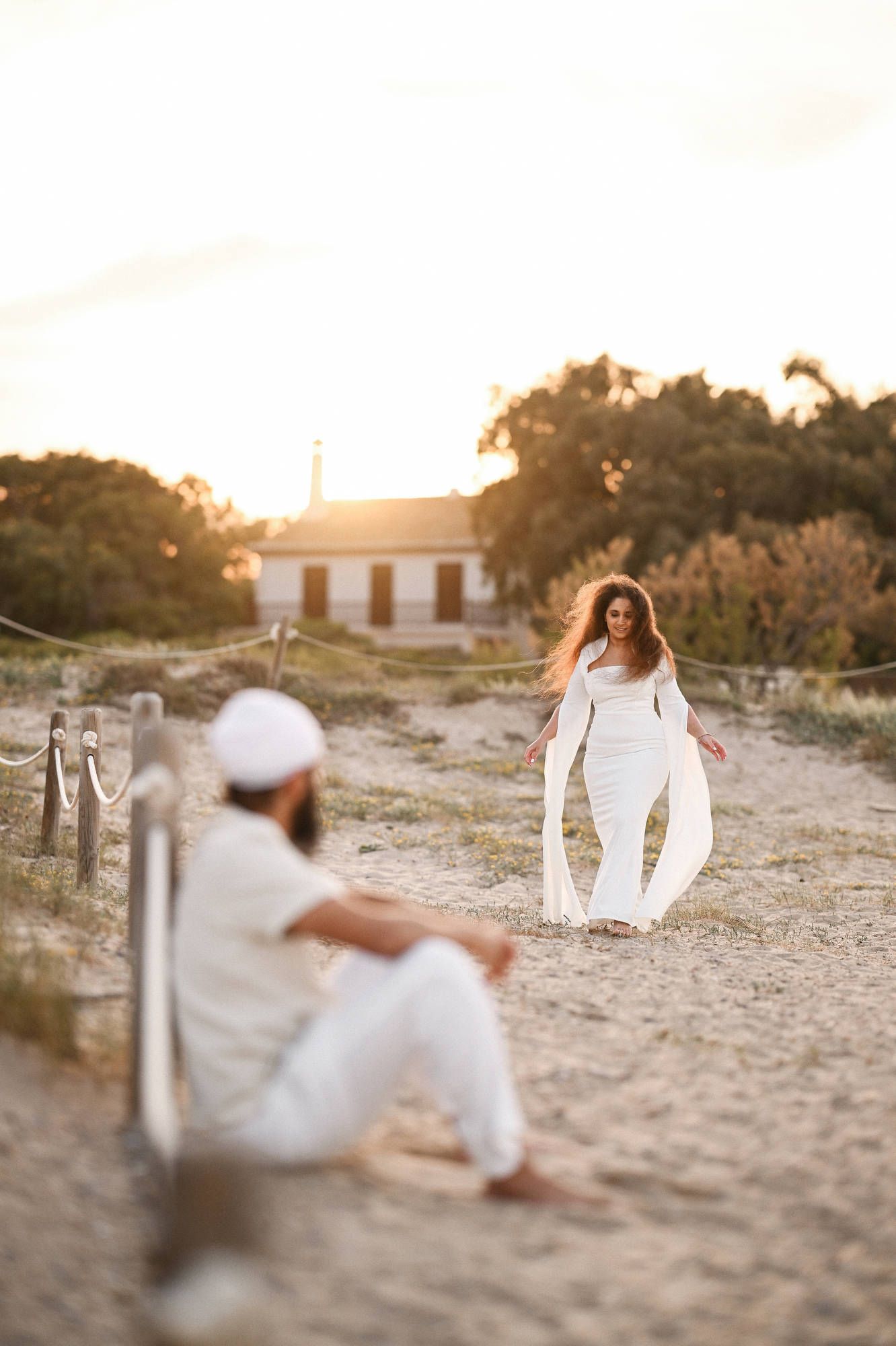 Happy woman walking towards her partner on the beach unaware of the upcoming surprise marriage proposal - Valencia photo and video session