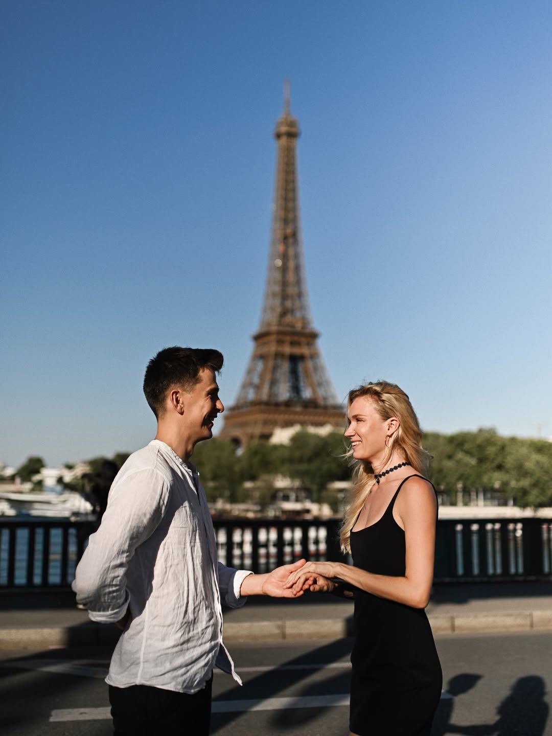 Moments before a surprise proposal on Pont de Bir-Hakeim in Paris, a man hides the ring while holding his partner's hand.