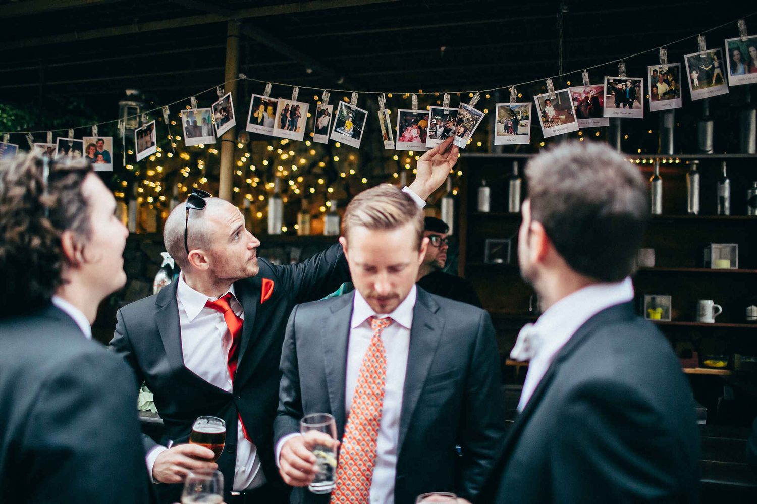 Wedding guest reviewing photos during a cocktail party. Candid moment captured by a European reportage photographer.
