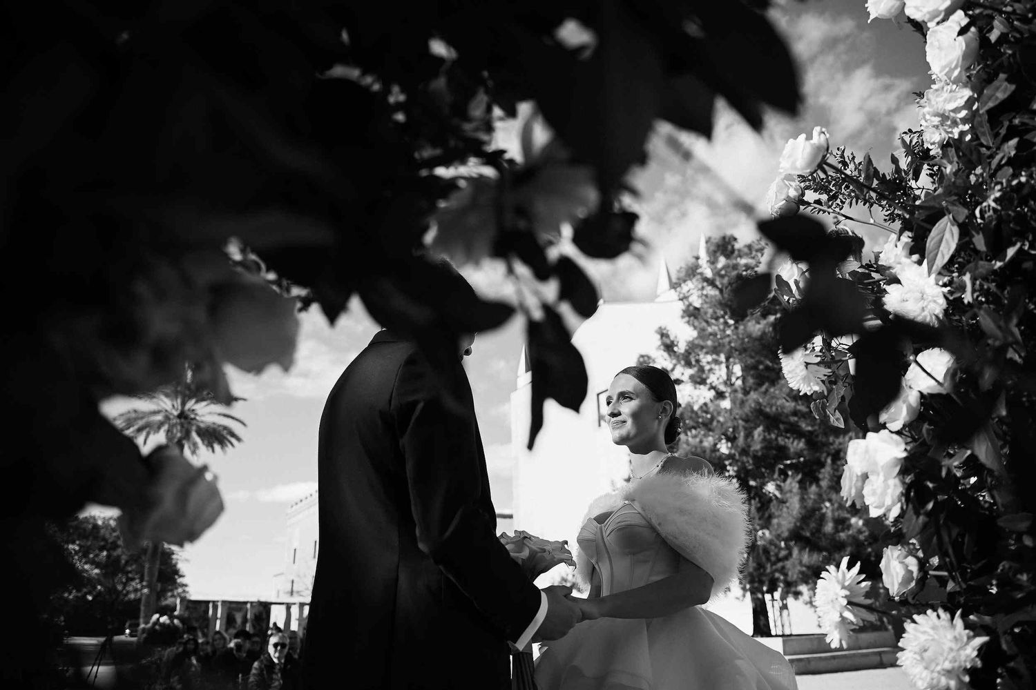 Cinematic detail of bride and groom holding hands during their wedding ceremony in the historical courtyard of Ara Christi, Valencia.