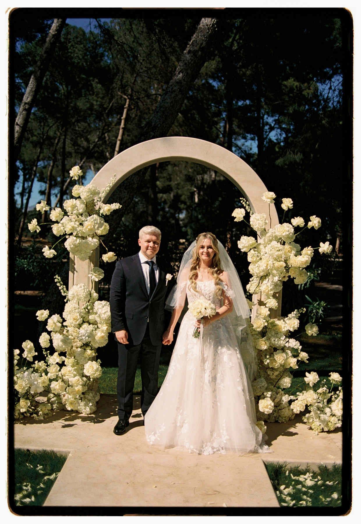 Bride and groom at a floral altar, shot on film and scanned at Carmencita Film Lab at Finca El Senyoret.