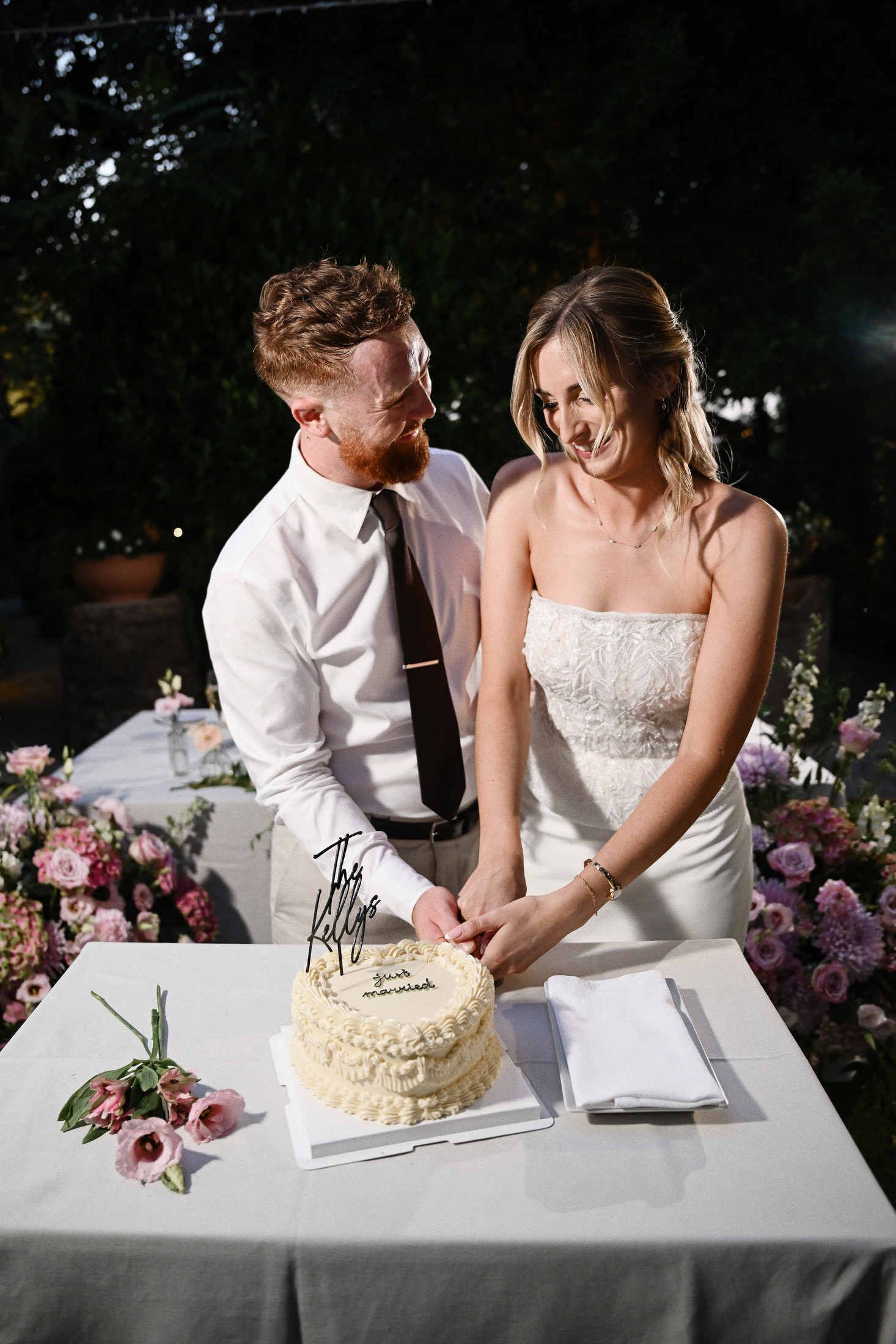 Bride and groom cutting their elegant wedding cake together at the end of the reception dinner at Villa Dela venue.