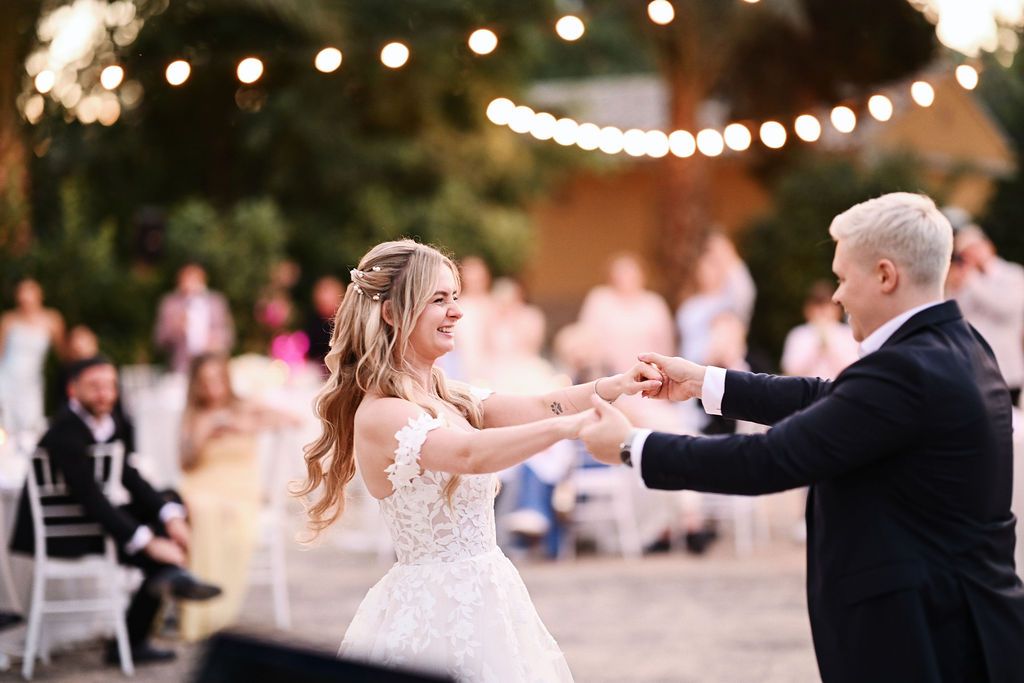 The wedding couple dancing their first dance surrounded by watching guests during a beautiful outdoor reception in the Benidorm area.