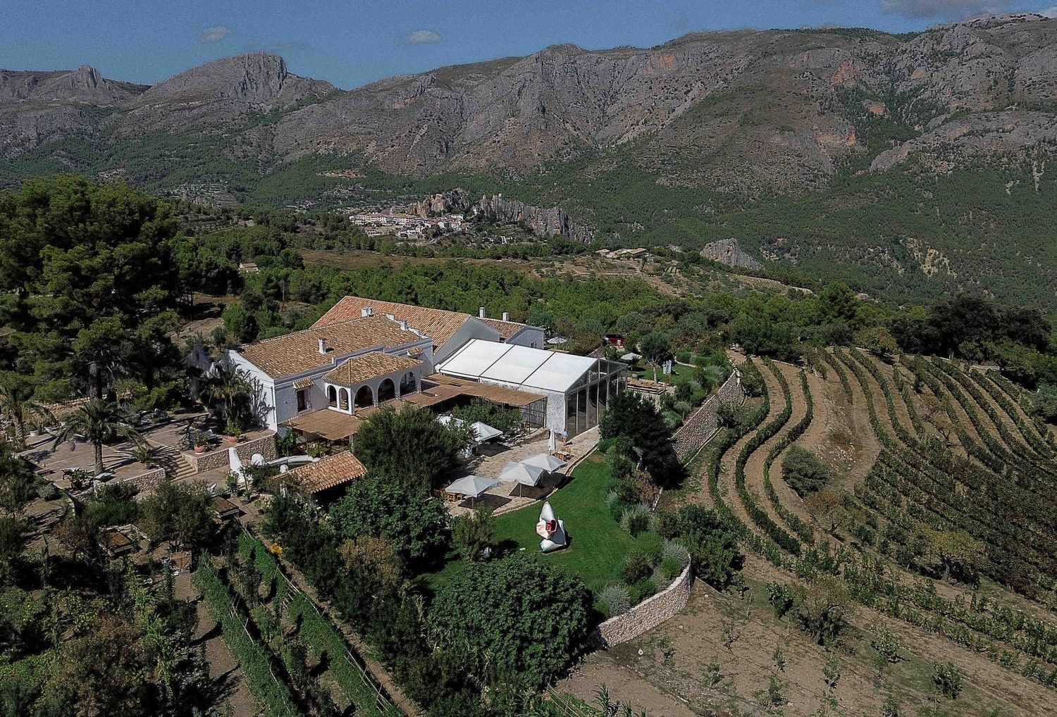 Elevated aerial view of Masos de Guadalest winery wedding venue, showing vineyards and the Aitana mountains.