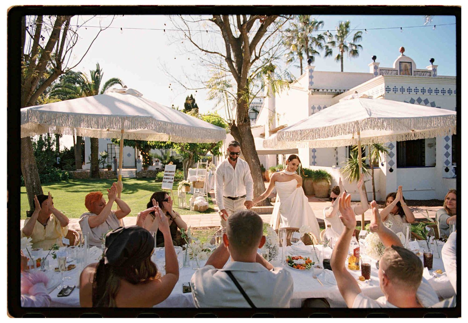 Bride and groom with a backdrop of scenic European villas during golden hour - editorial 35mm film photographer in Europe analog style
