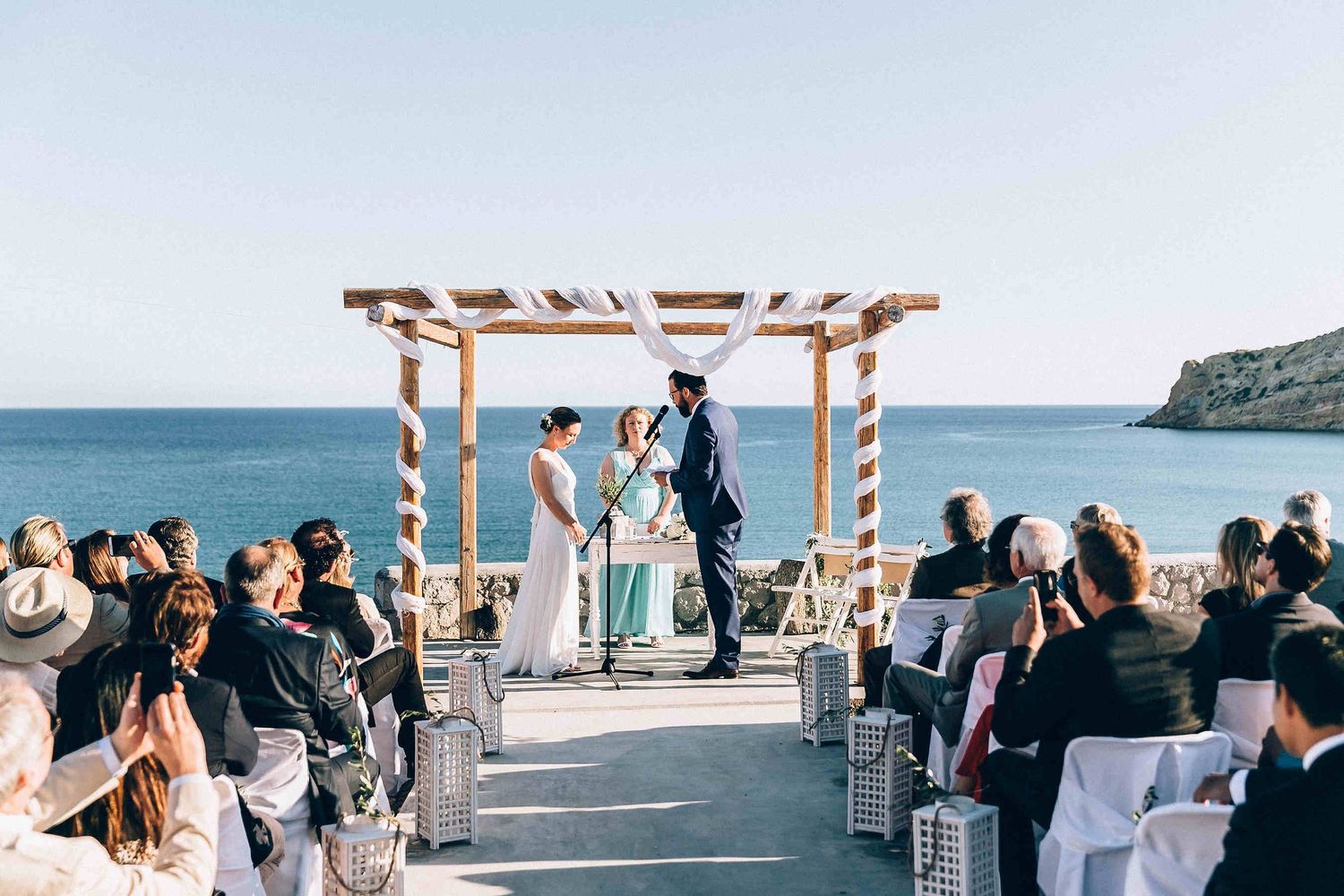 Wide-angle landscape of a wedding ceremony in Greece with a limitless sea horizon