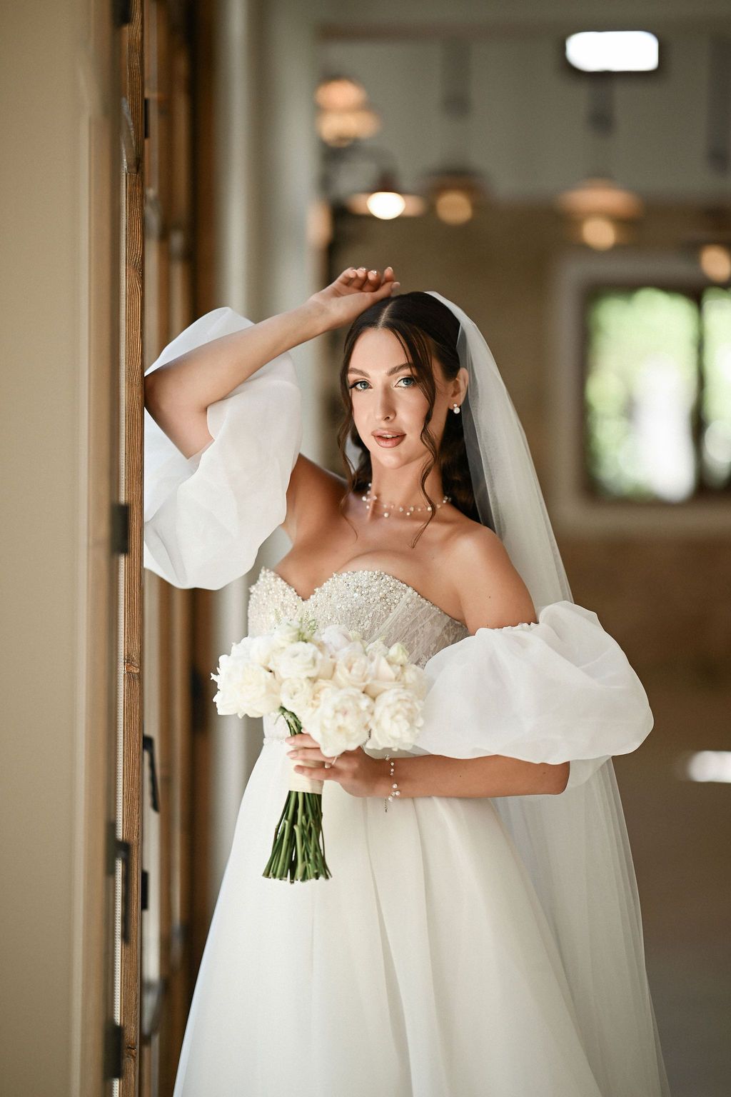 A stunning portrait of the bride in her luxury wedding dress holding a bouquet and looking into the camera at Finca del Canónigo.