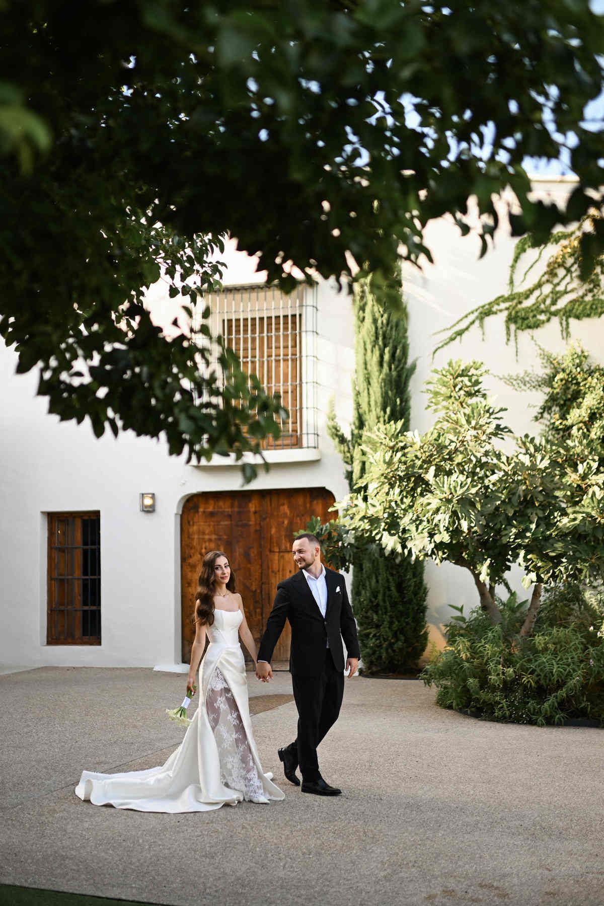Bride and groom walking through the expansive courtyard of El Telar, showcasing the historic estate atmosphere. Photo by Darista