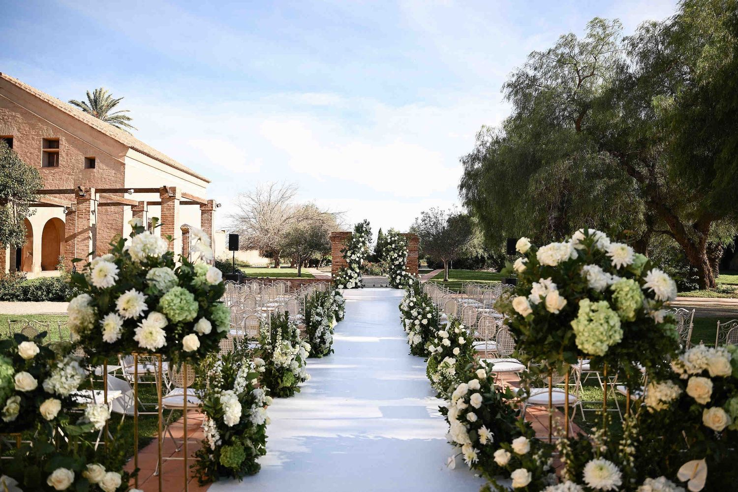 Elegant wedding ceremony setup and floral decor in the ancient courtyard of La Cartoixa d'Ara Christi, a premier Valencia luxury venue.