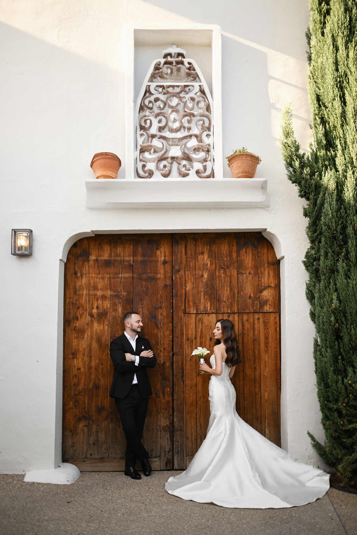 Bride and groom posing against the raw industrial facade of El Telar. Modern editorial wedding portrait captured by Darista.
