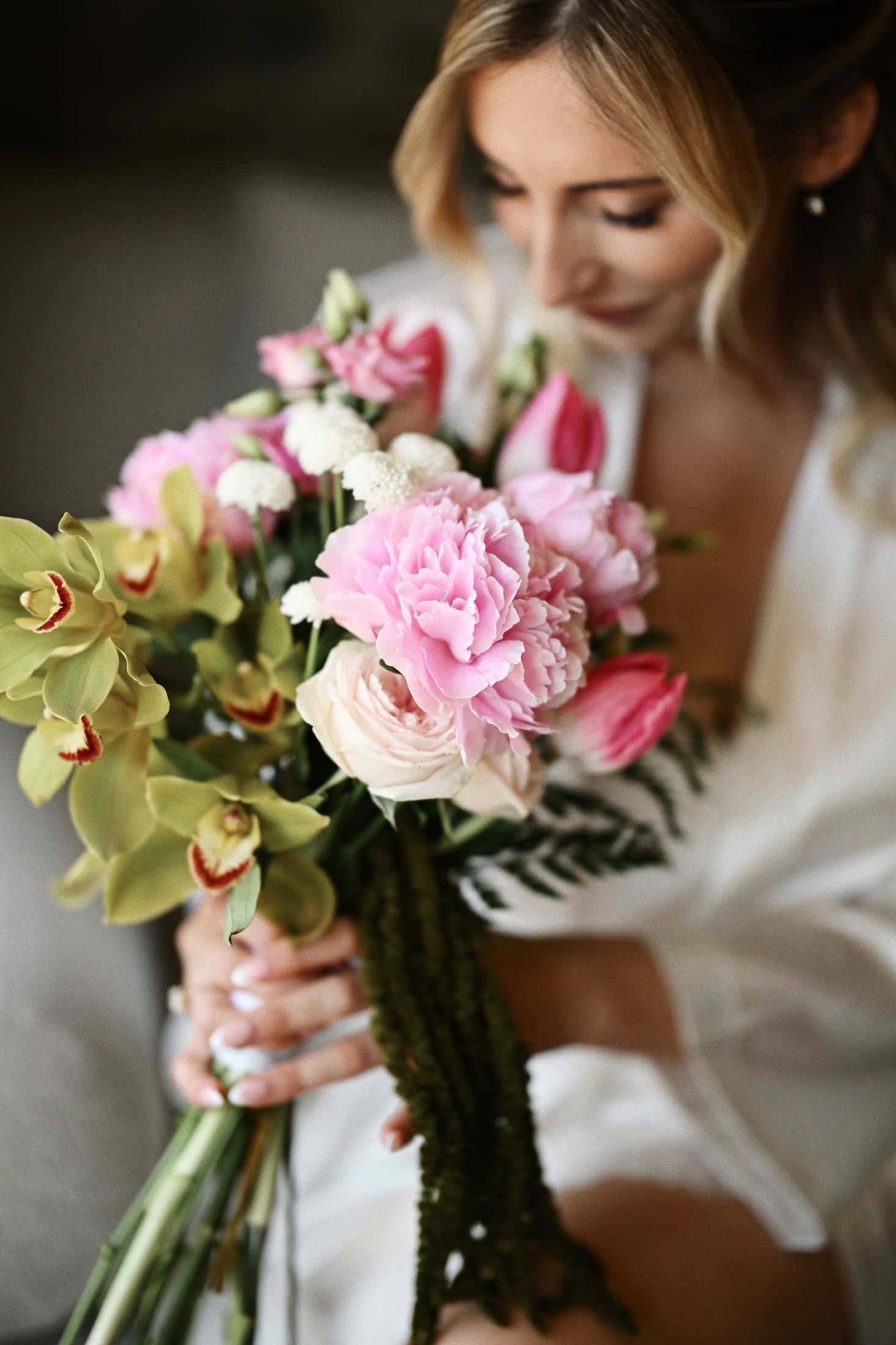 Bride holding a beautiful wedding bouquet while posing for a photographer during bridal prep in Valencia, Spain.