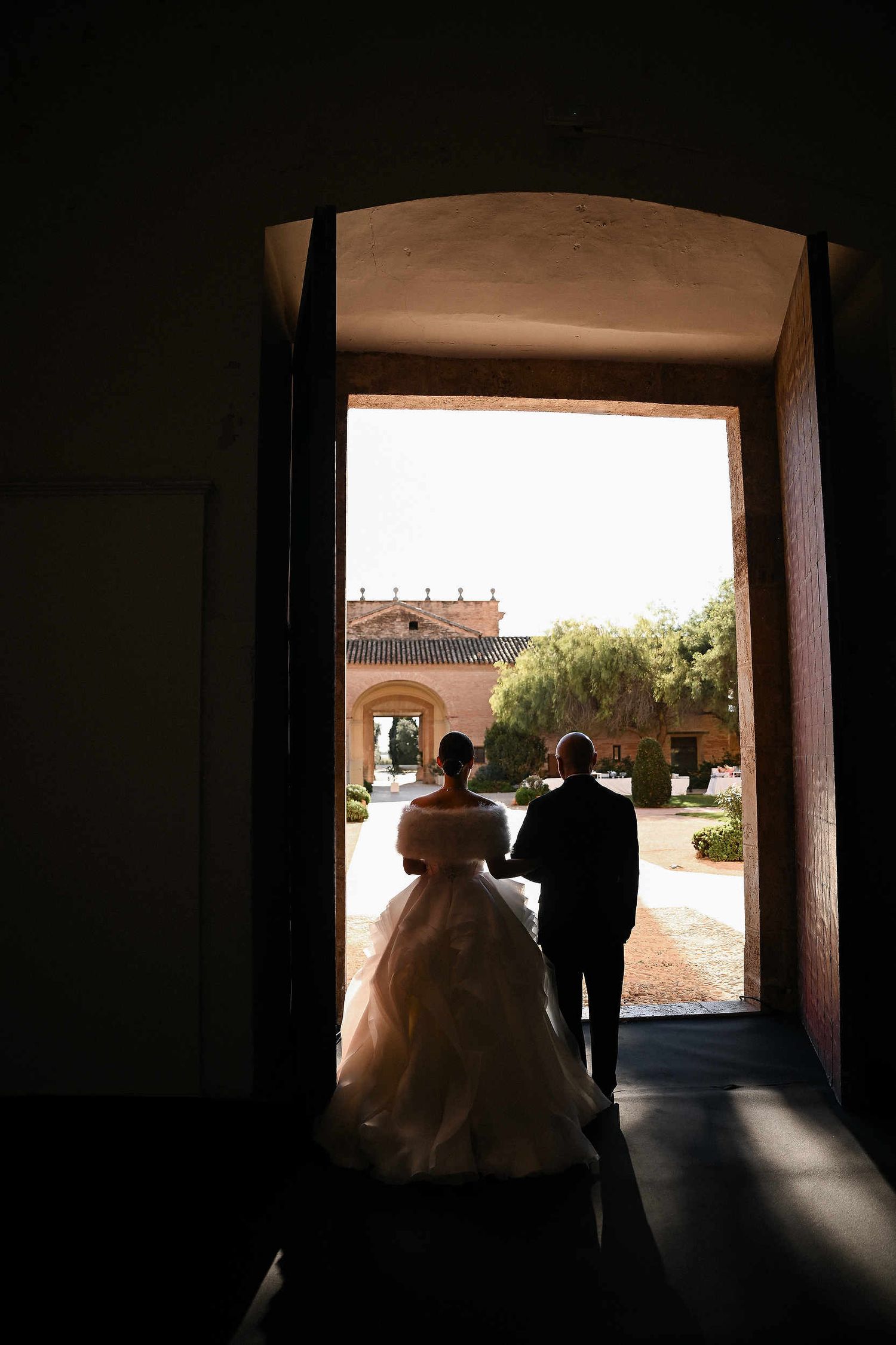 A quiet, cinematic moment between father and bride just seconds before walking down the aisle at Ara Christi monastery.