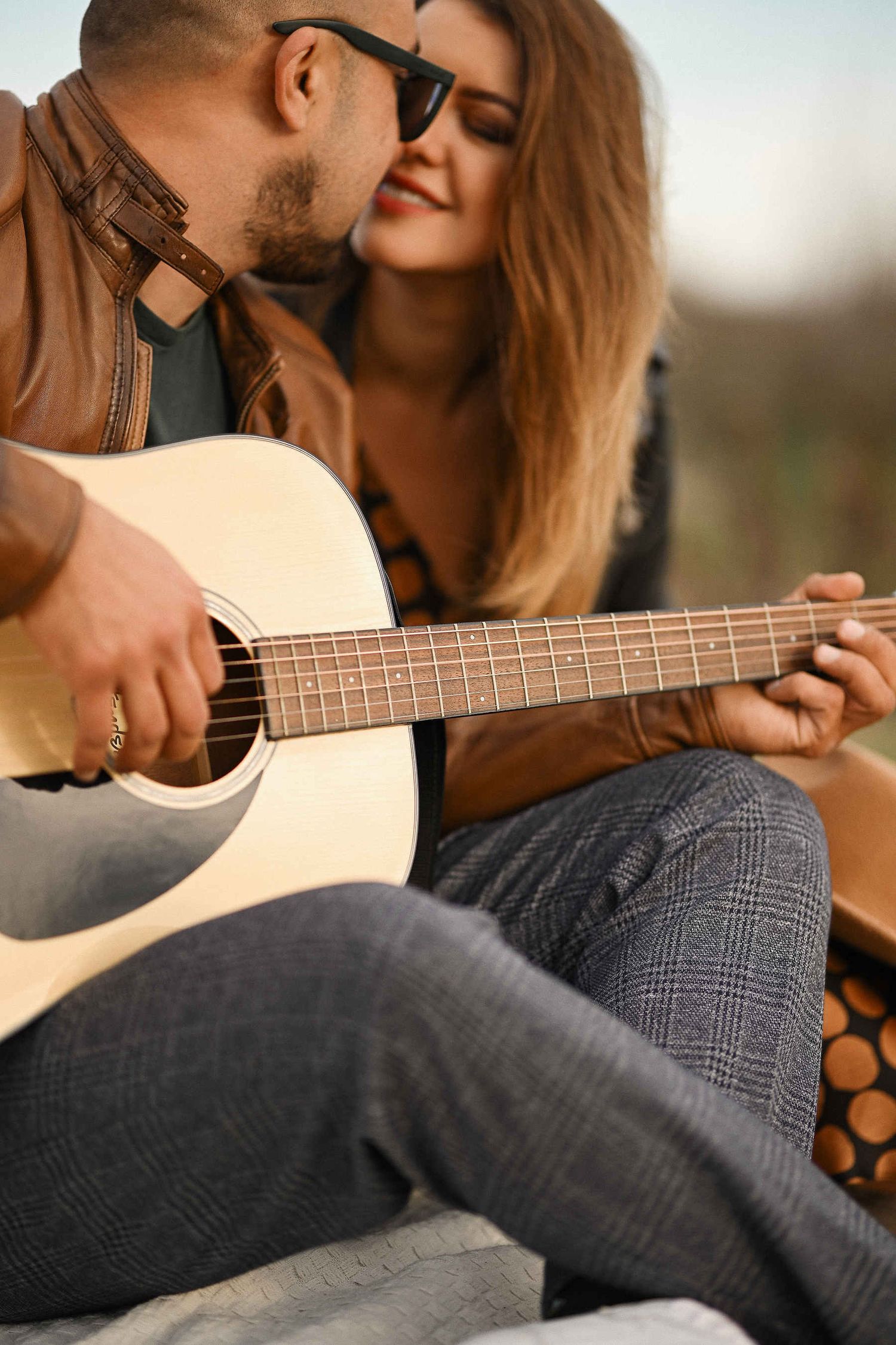 Close-up detail shot of a guitar on the sand during a storytelling Valencian beach engagement photoshoot