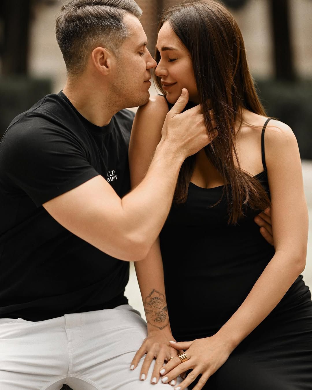 Intimate love story moment in Viveros Park as a man gently touches a woman's neck before a kiss in warm daylight.