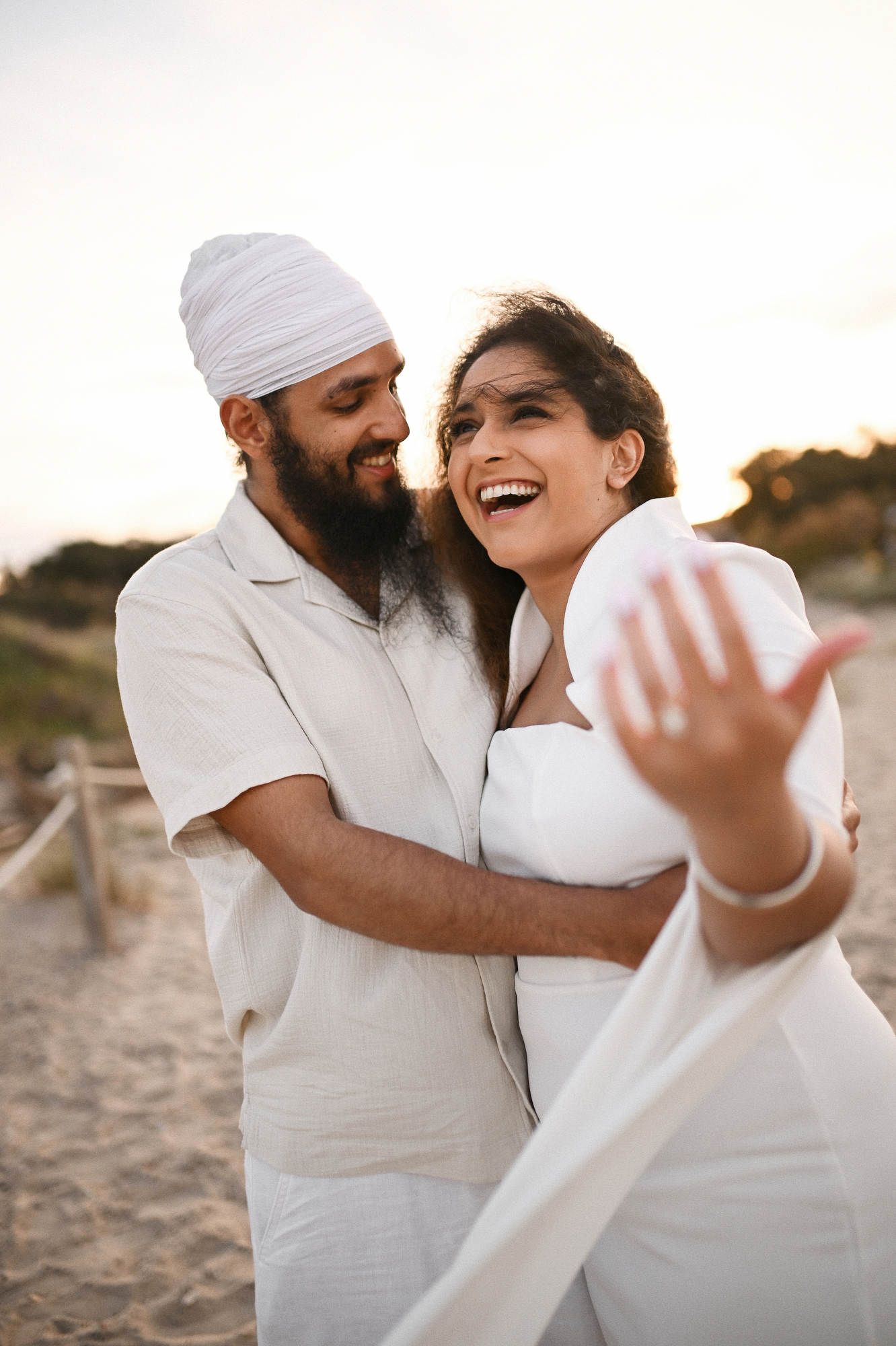 Raw emotions as couple hugs after beach proposal captured by a secret photographer - candid surprise engagement photography Valencia