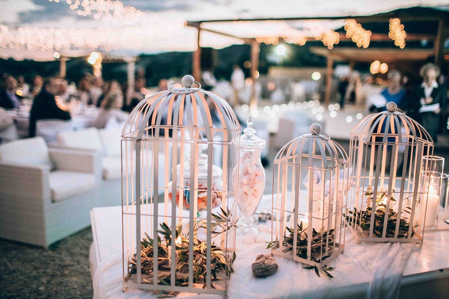 Atmospheric twilight wedding dinner illuminated by fairy lights and romantic candles