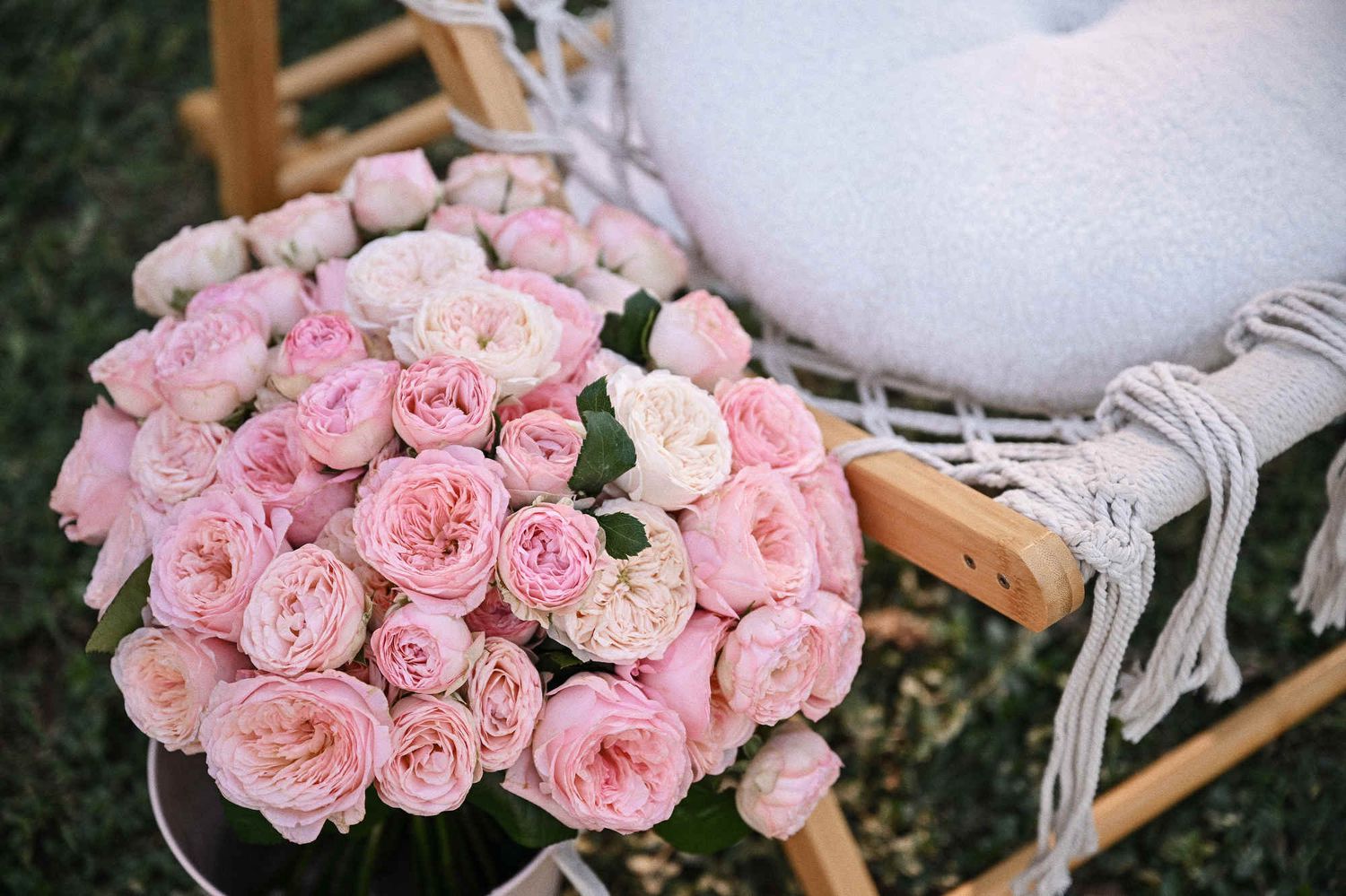 Close-up of a lush pink rose bouquet on a macrame chair ready for a marriage proposal at Jardin del Real.