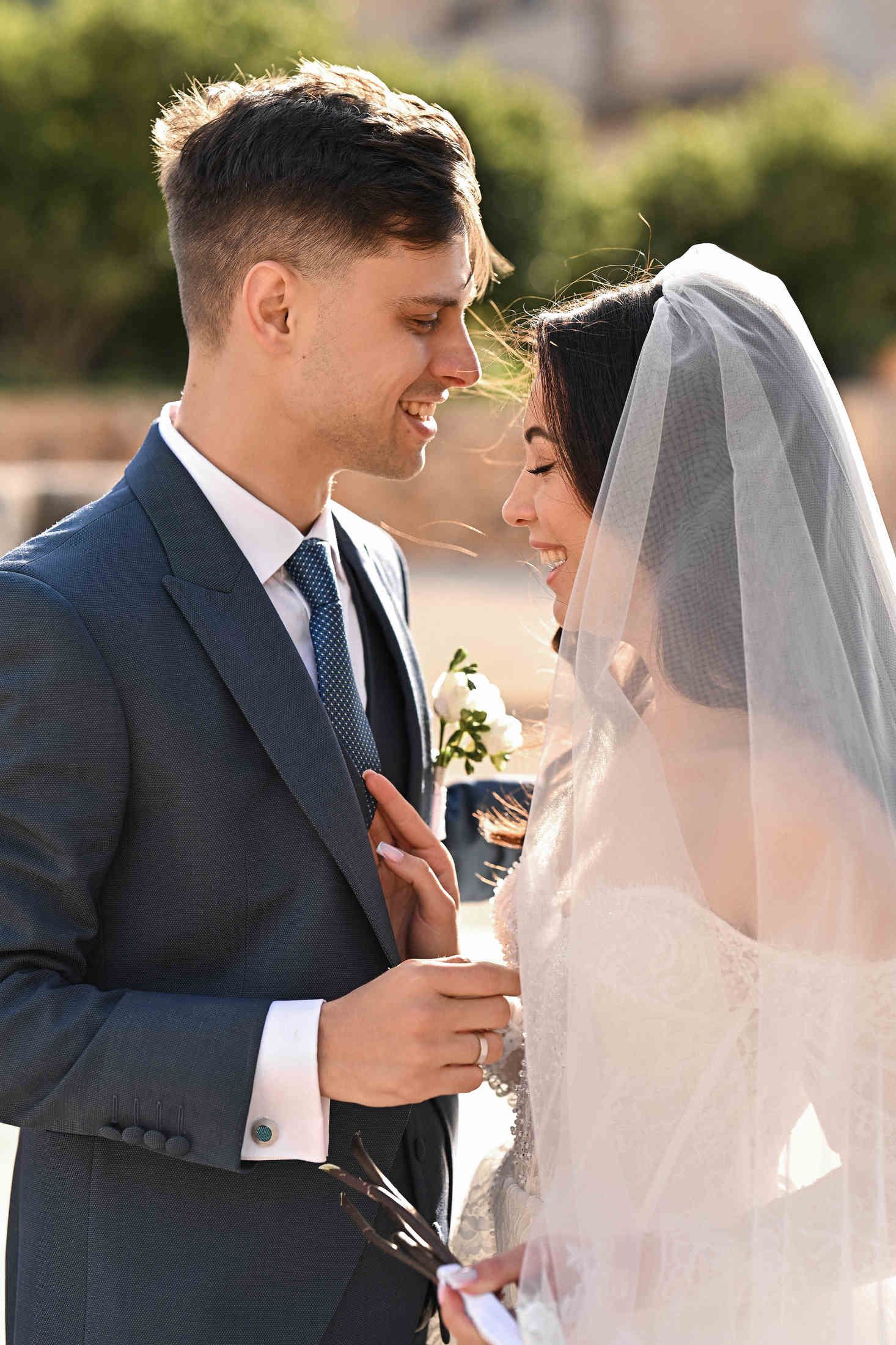 Emotional wedding portrait of a bride and groom smiling and looking into each other's eyes at Monasterio de Santa María de la Valldigna.