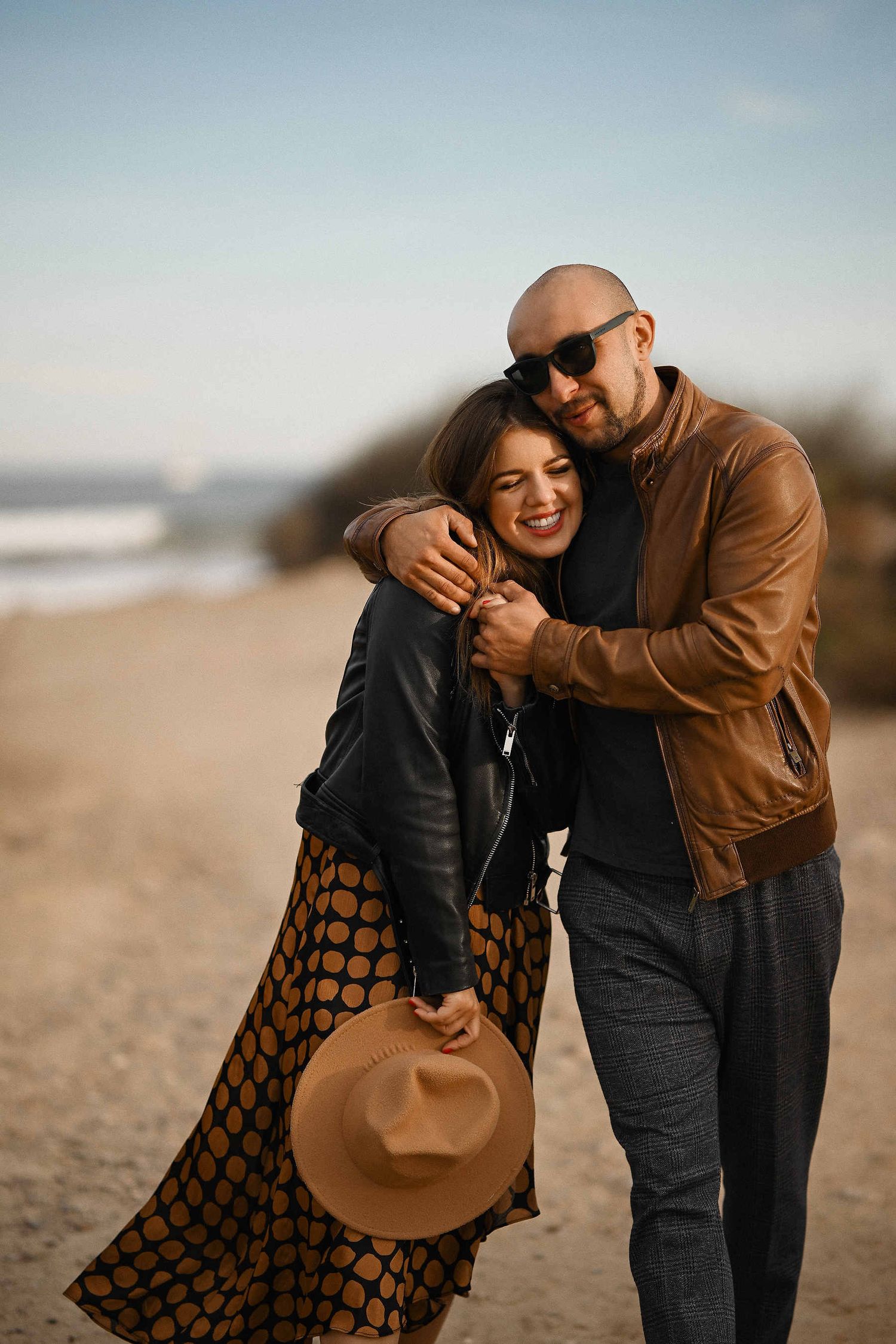 Happy couple laughing together during an authentic engagement photoshoot on a Valencia beach