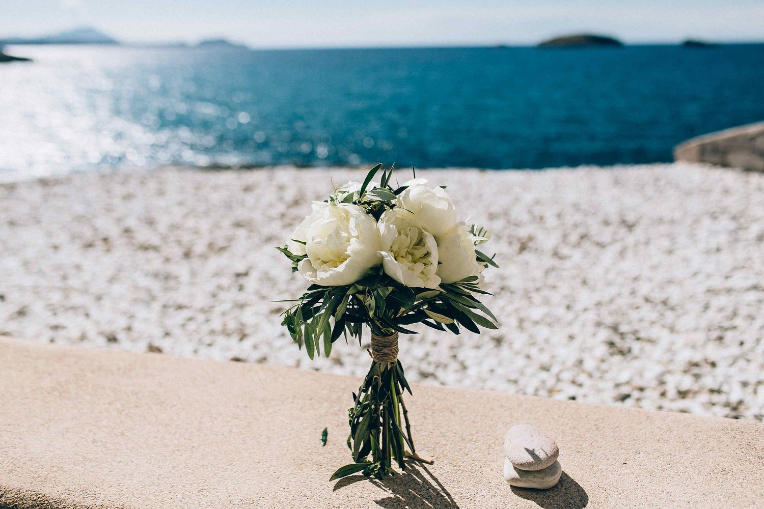 Wedding floral arrangement with the deep blue Aegean Sea in the background.