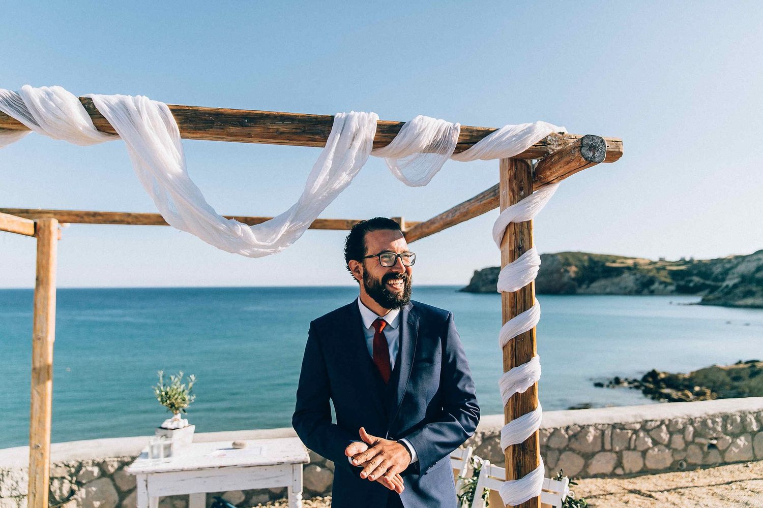 Anxious and excited groom waiting for the bride at the altar during a destination wedding in Greece