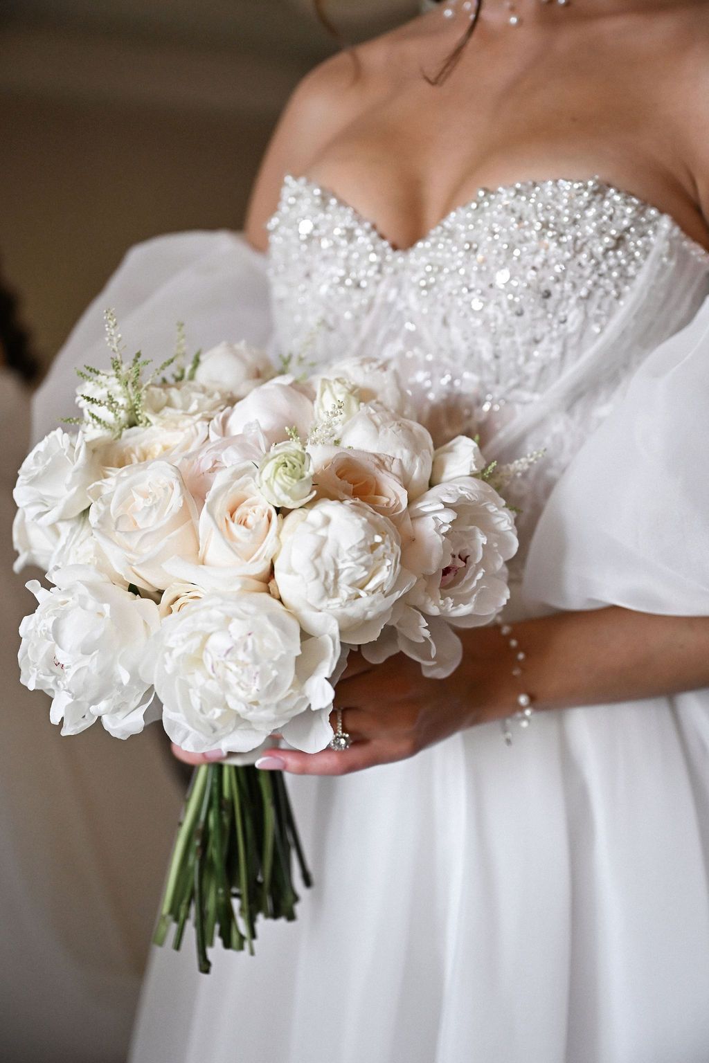 Close-up luxury detail shot of the bridal bouquet and elegant wedding dress neckline during a destination wedding at Finca del Canónigo.