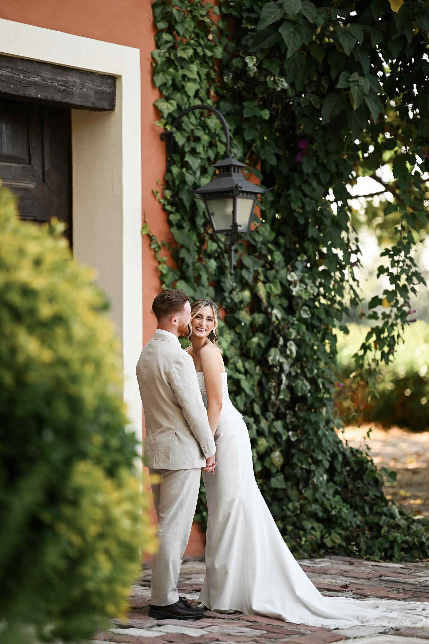 Bride and groom walking through the lush Mediterranean gardens and green scenery of Villa Dela wedding venue in Valencia.