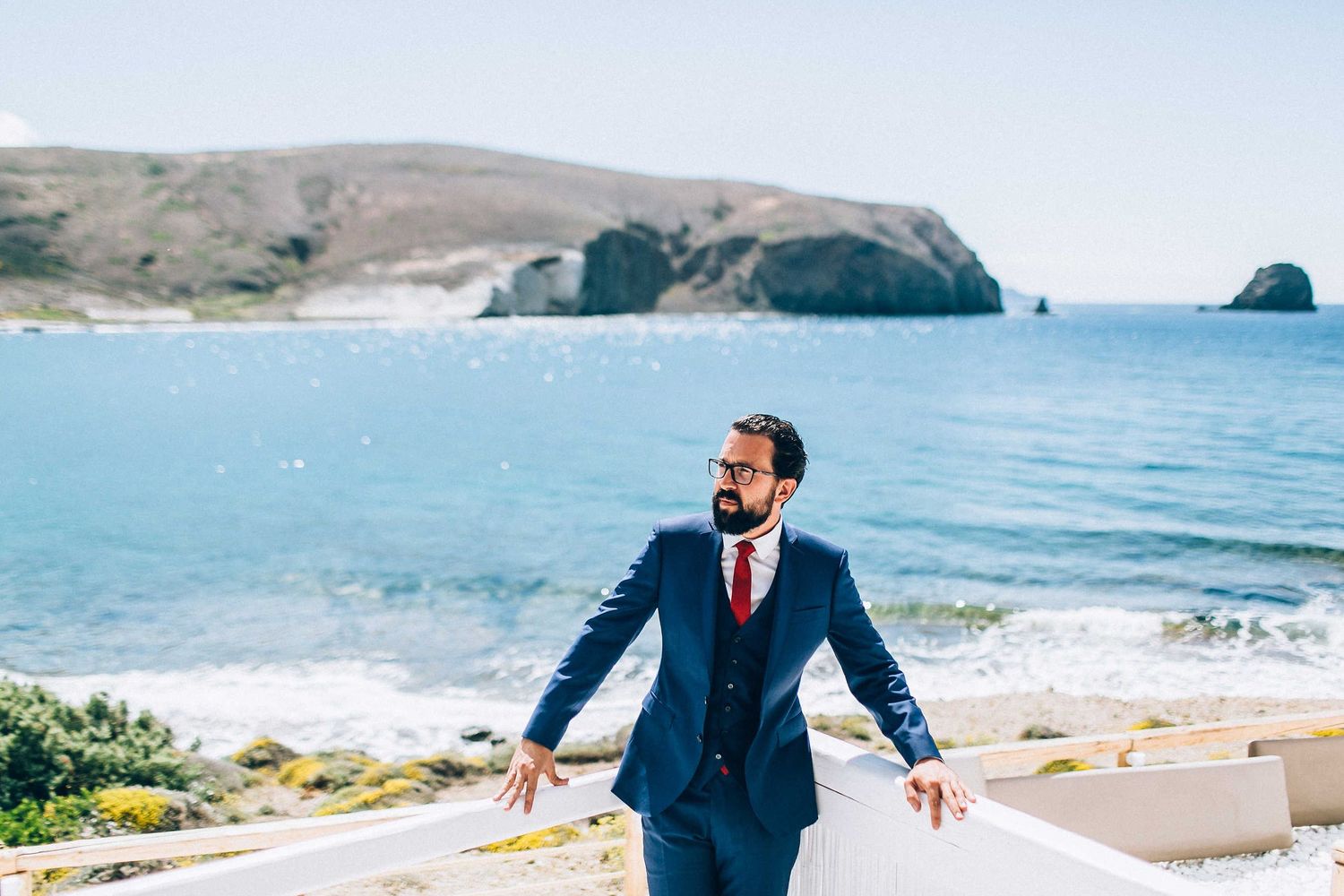 Full length portrait of a stylish groom in a modern suit at a Milos villa