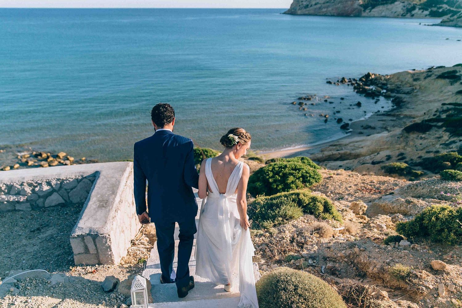 Happy just-married couple walking down the beach