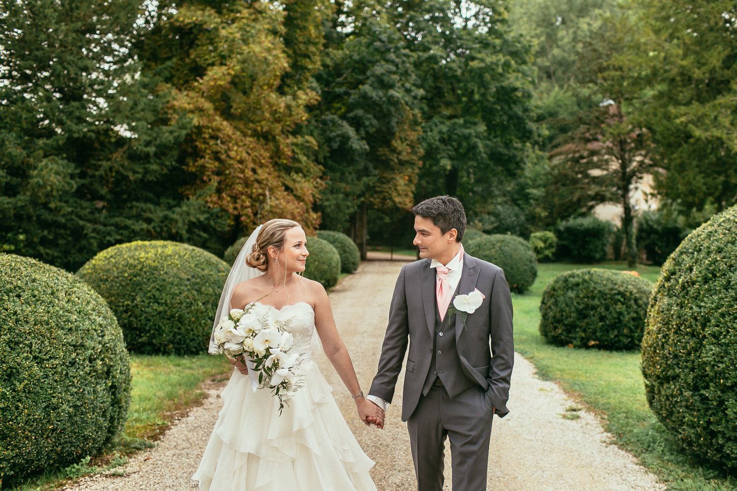 Artistic play of light and shadows during a couple's walk at Château de Changy. Moody, cinematic wedding photography in France