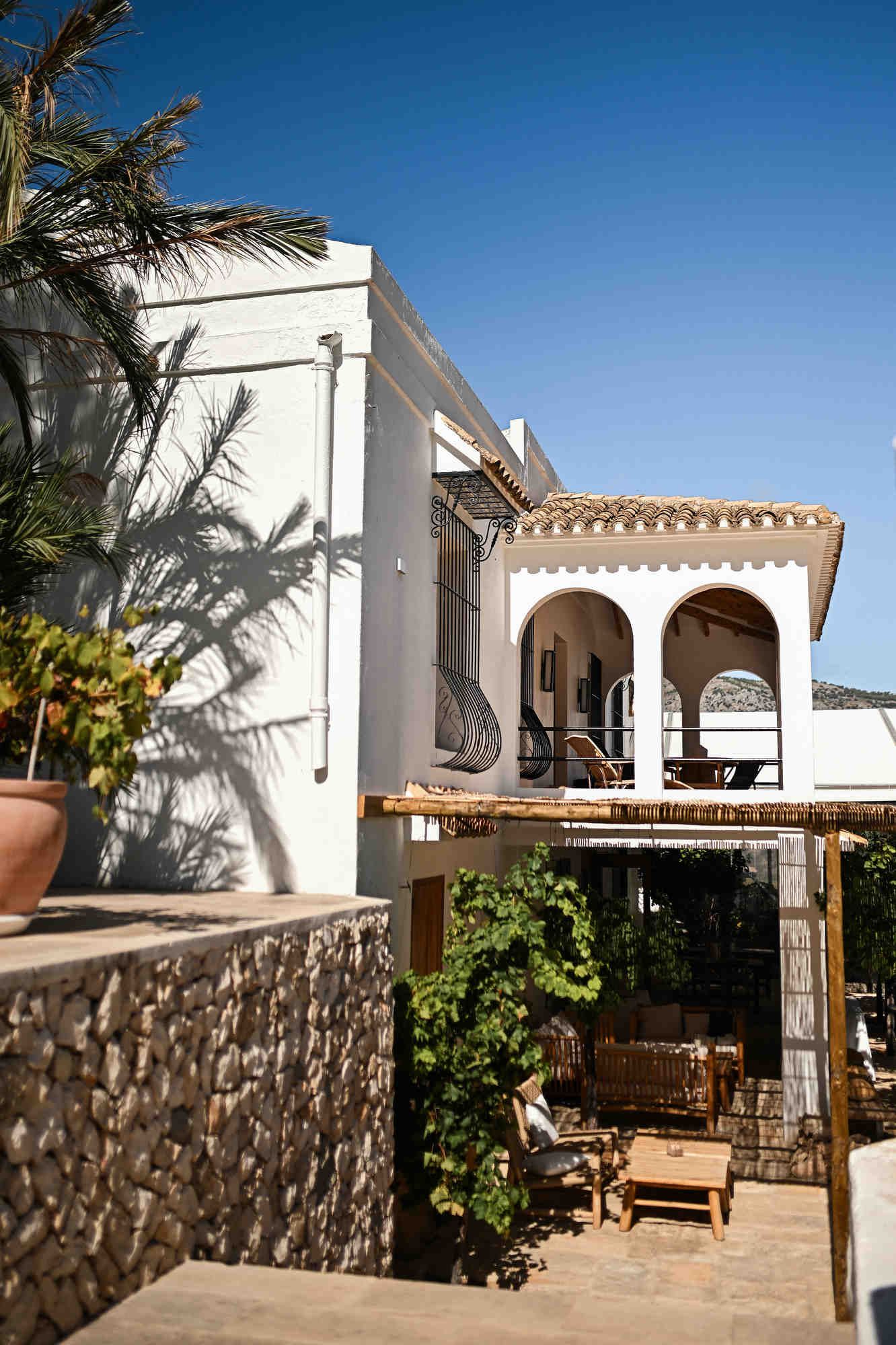 Whitewashed Mediterranean architecture and shaded terrace with grapevines at Bodega MASOS