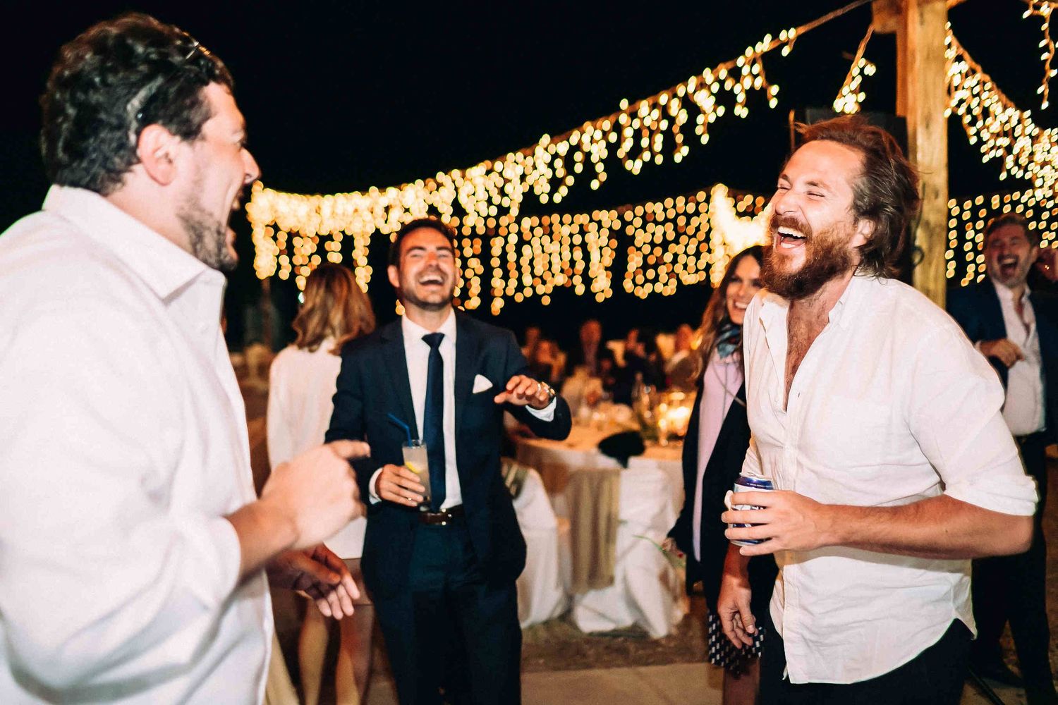 Excited wedding guests having fun and dancing wildly at the evening reception