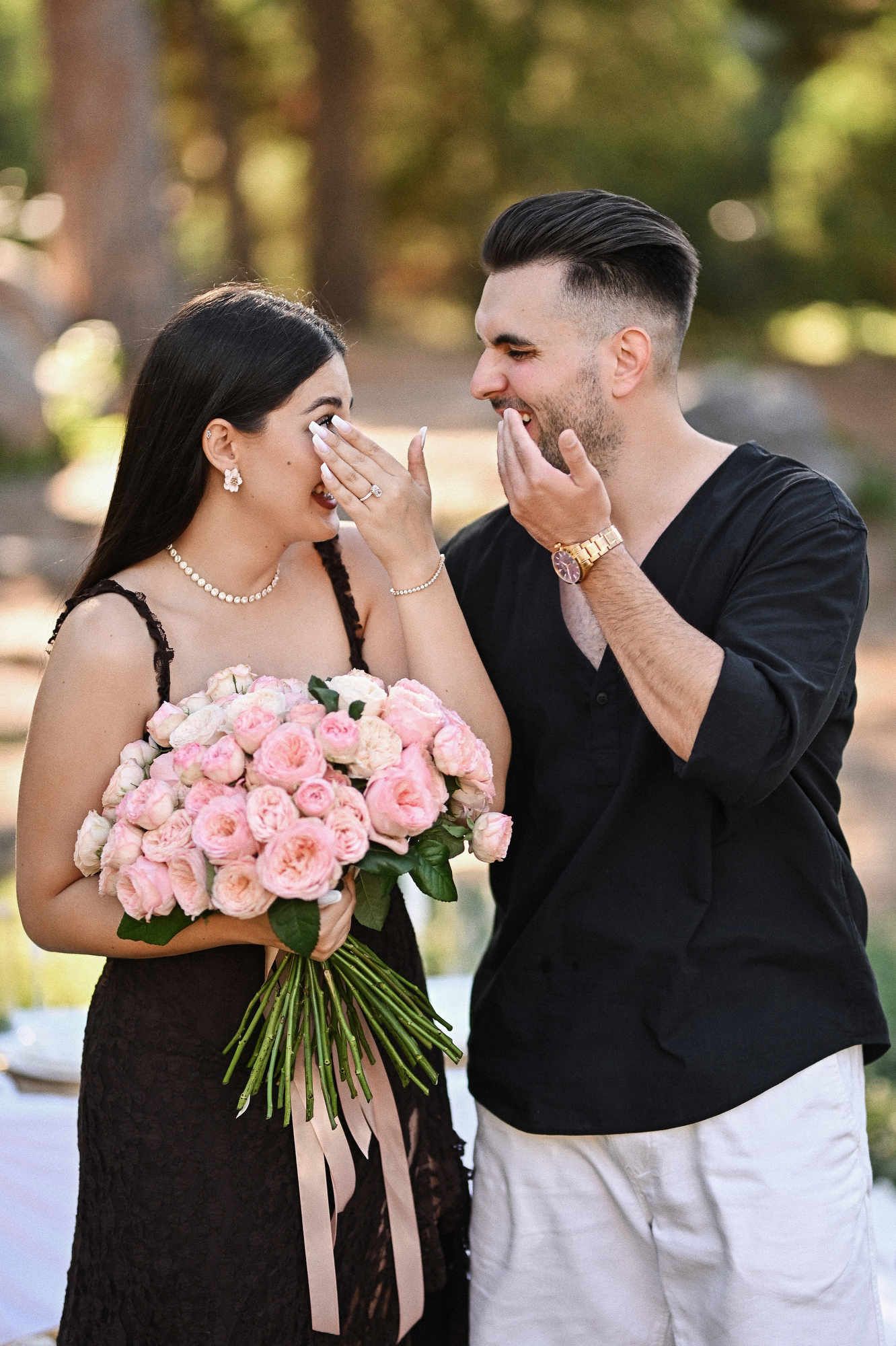 Woman wiping away happy tears while her fiance laughs during an emotional secret proposal at Jardin del Real.