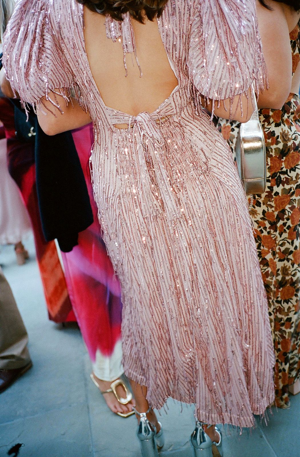 Back view of a blush pink beaded flapper-style dress at an elegant event.