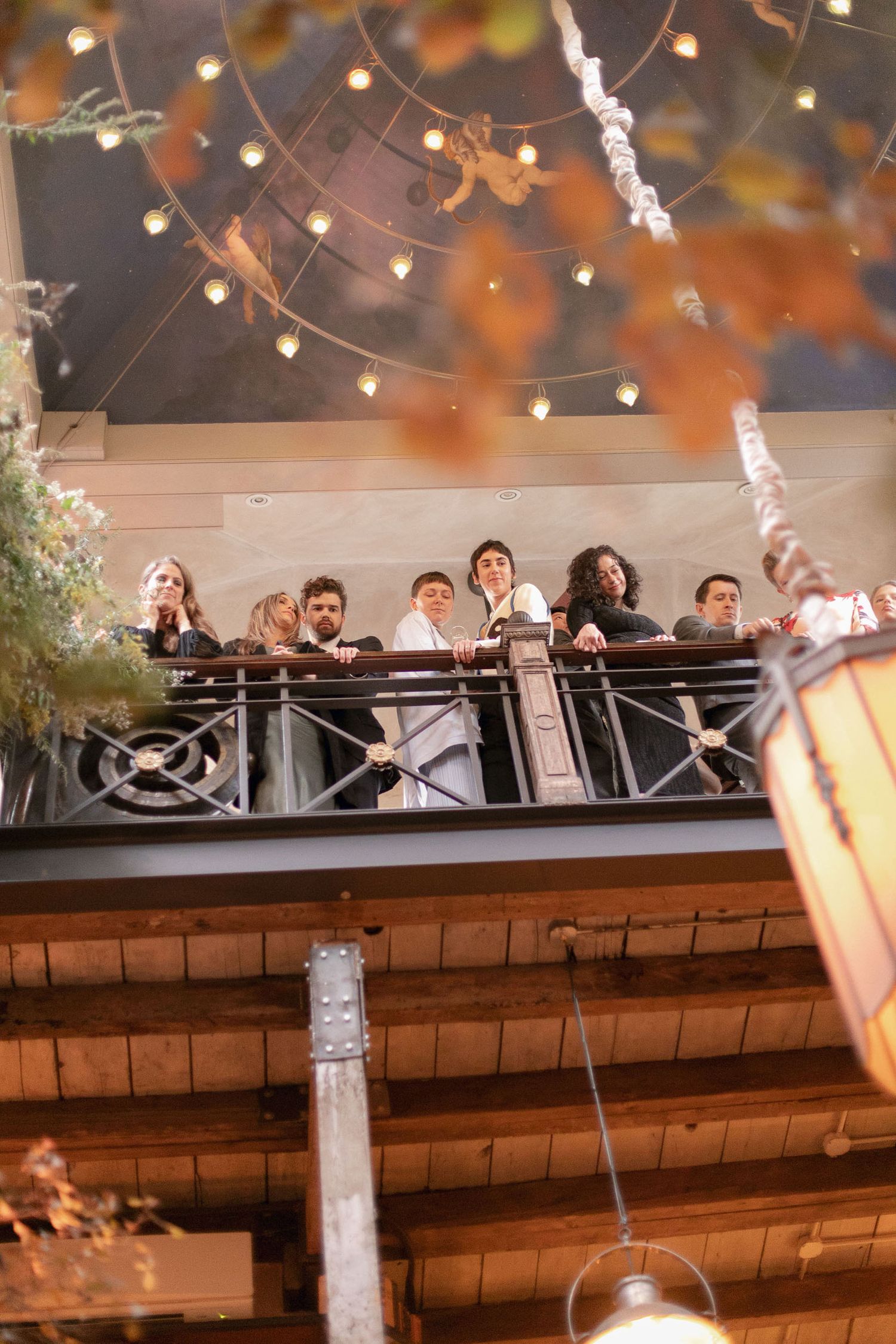 String lights and autumn-toned decorations create a warm ambiance in an indoor celebration space.