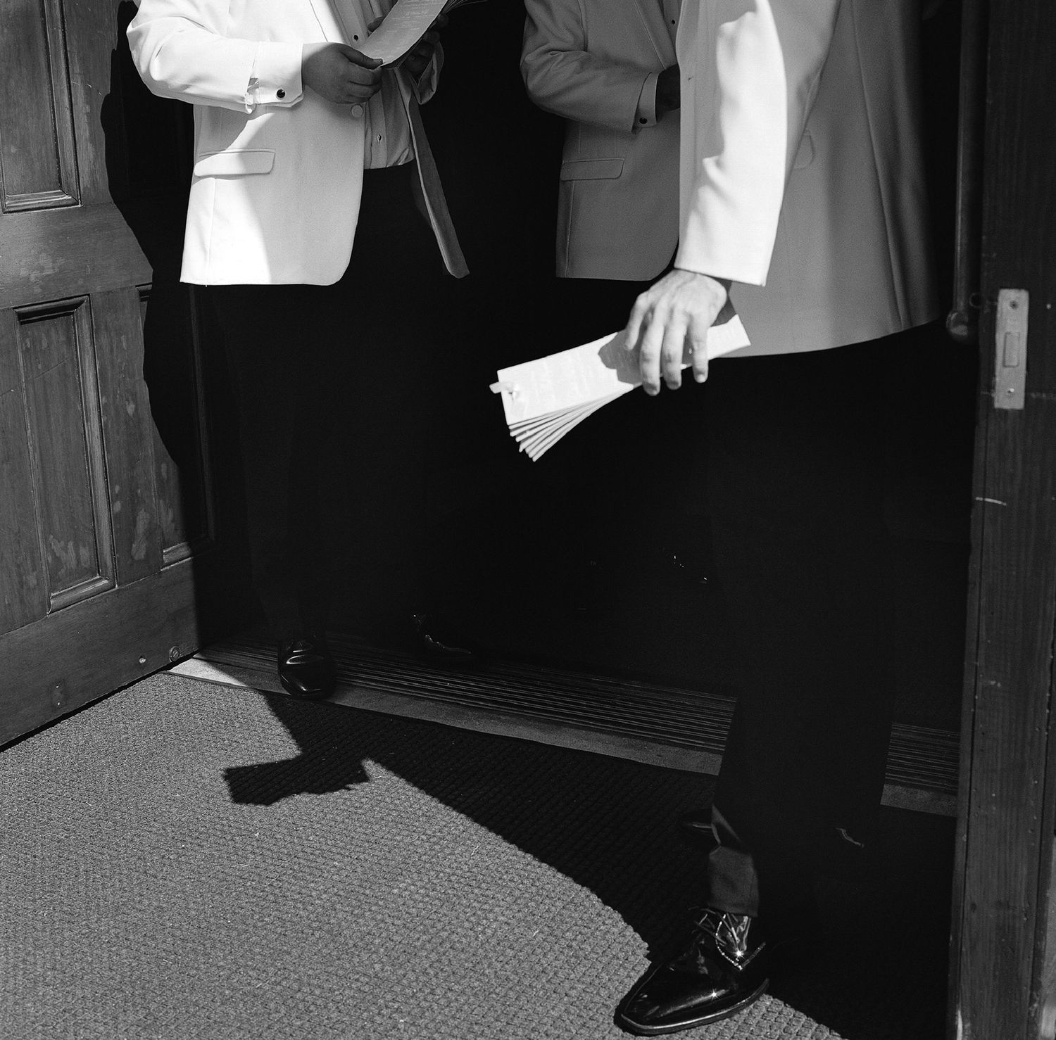 Black and white photo showing formal attire and dress shoes.