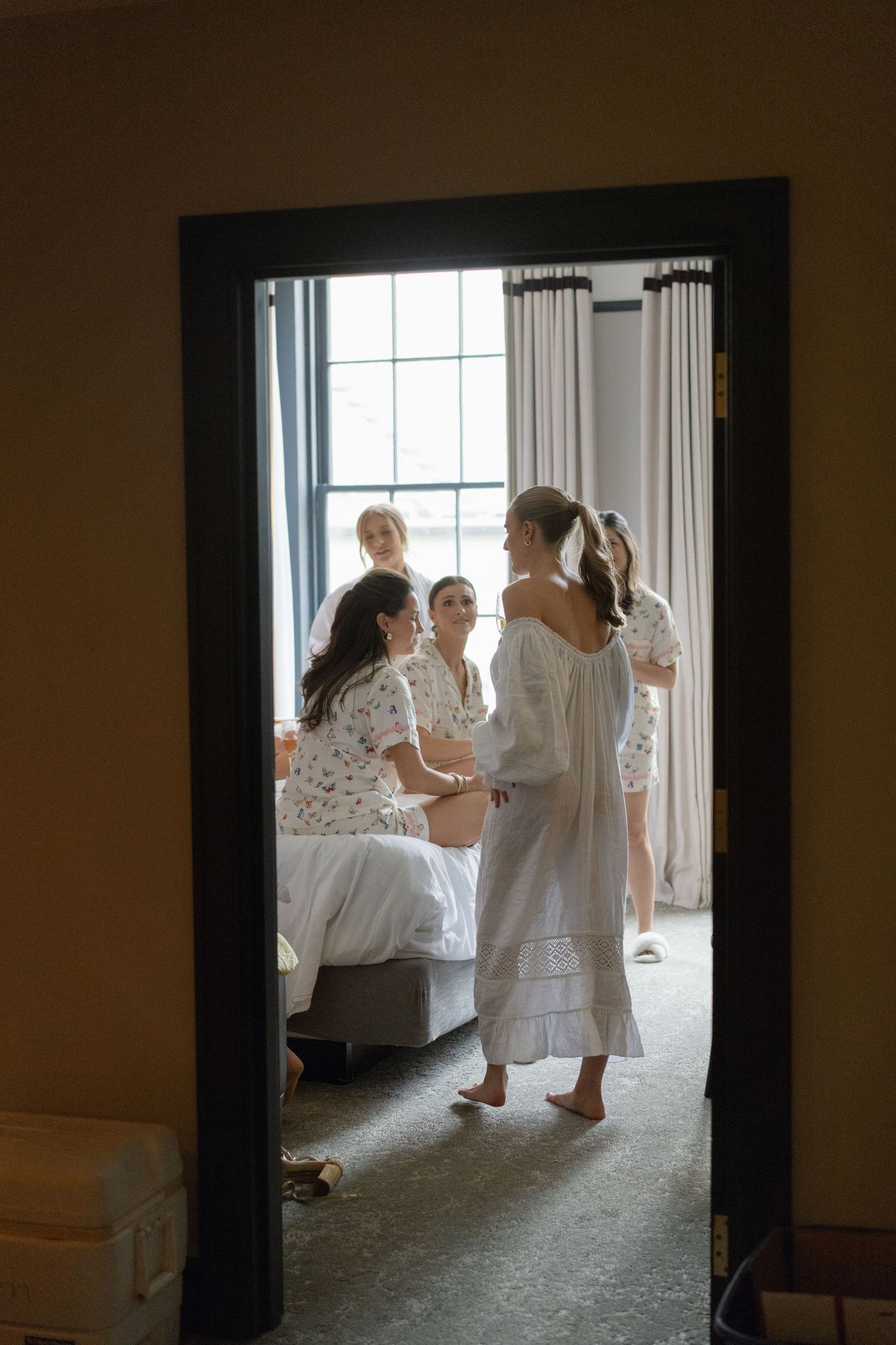 Soft natural light streams through windows illuminating figures in white clothing.