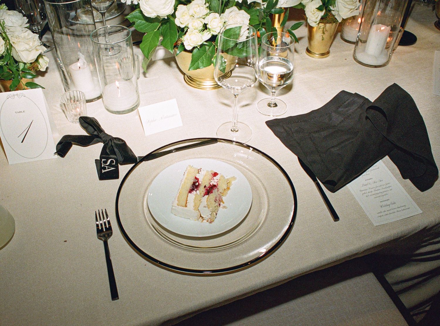 Elegant table settings with white floral centerpieces and glassware at a formal wedding reception.