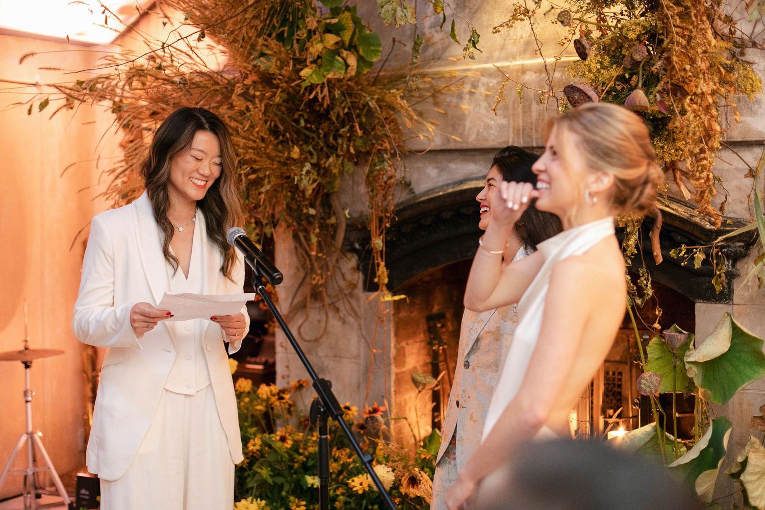 Wedding guests sharing joyful moments at an elegant indoor reception with warm lighting and natural decor.