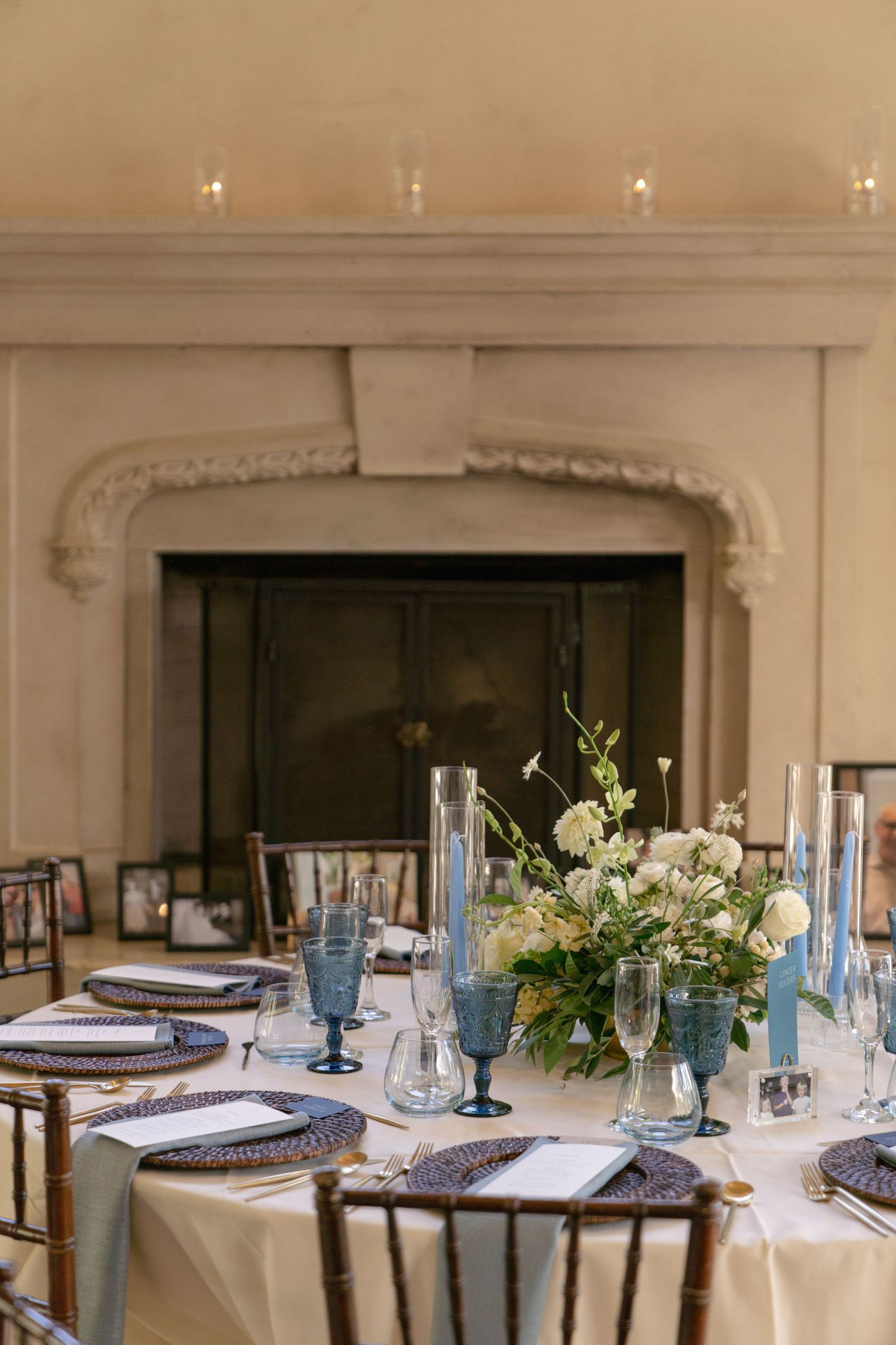 Elegant wedding reception table with blue glassware and white floral centerpieces.