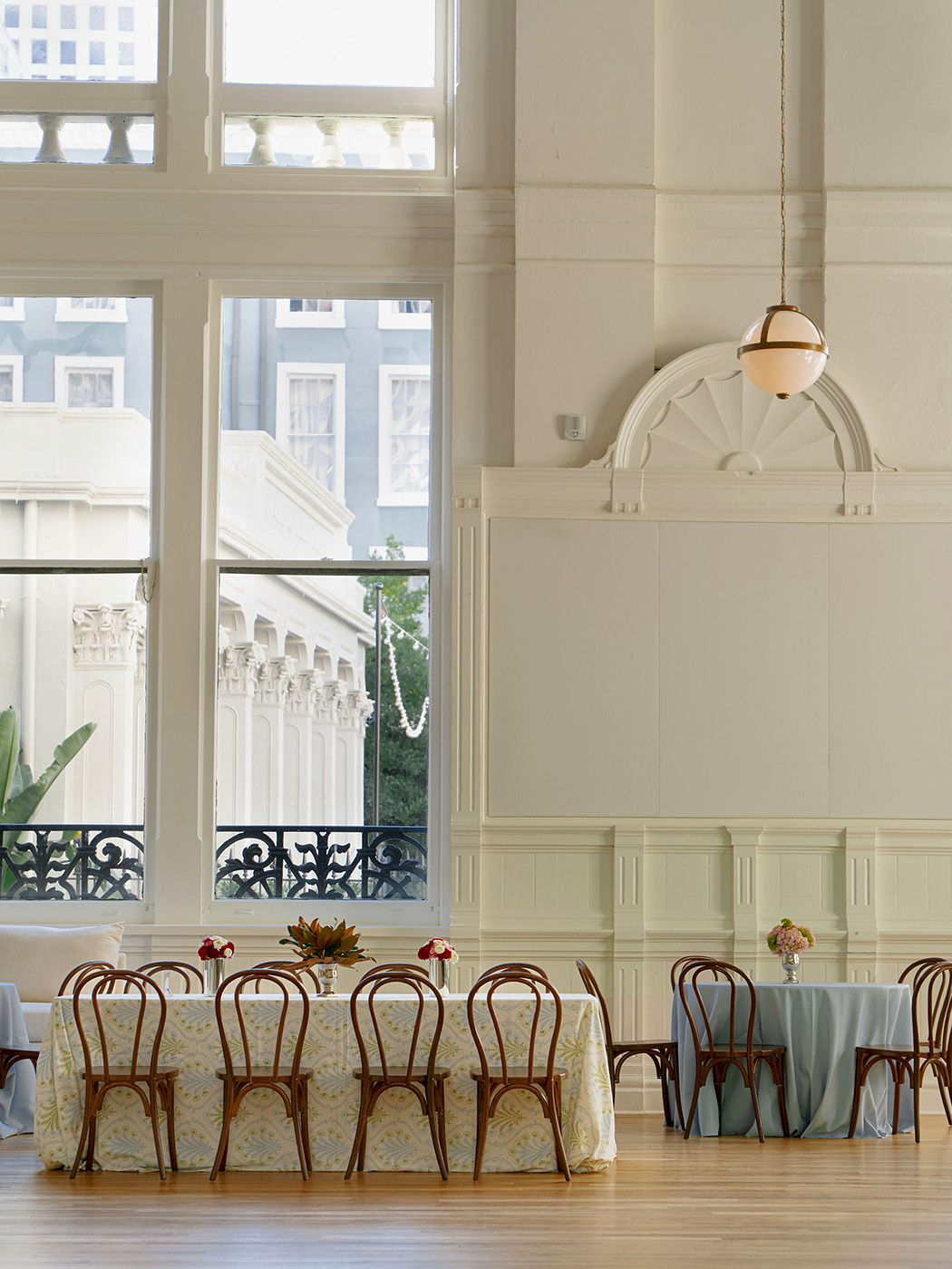 An elegant reception venue with bentwood chairs and large windows letting in natural light.