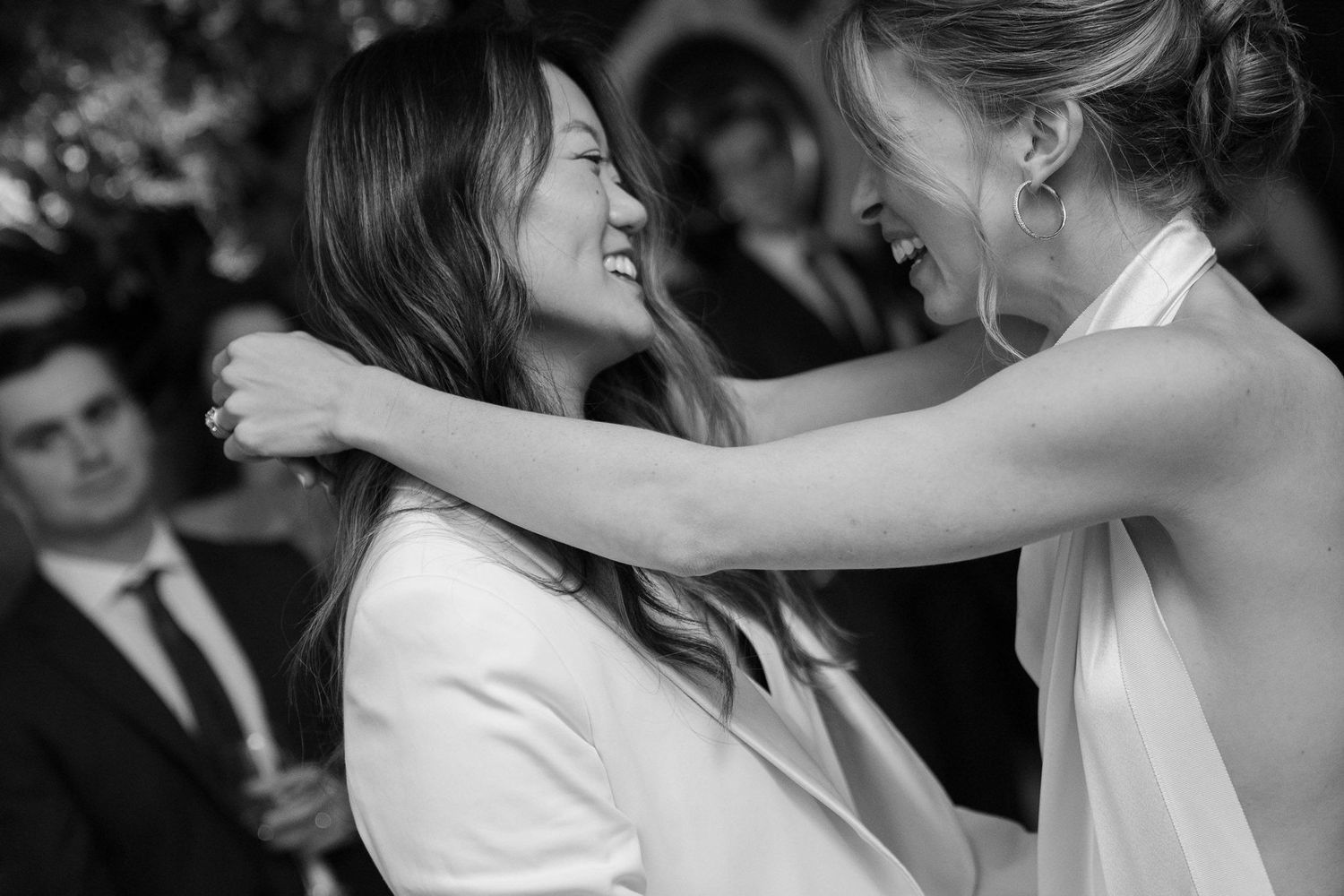 Couples dancing together at a wedding reception in black and white photography.