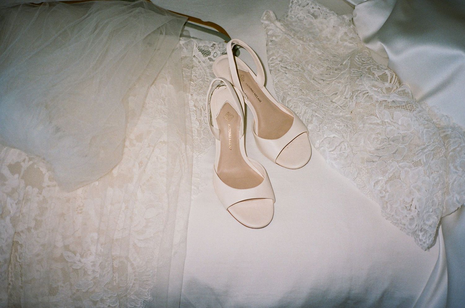 Close-up details of delicate lace wedding dress and shoes.