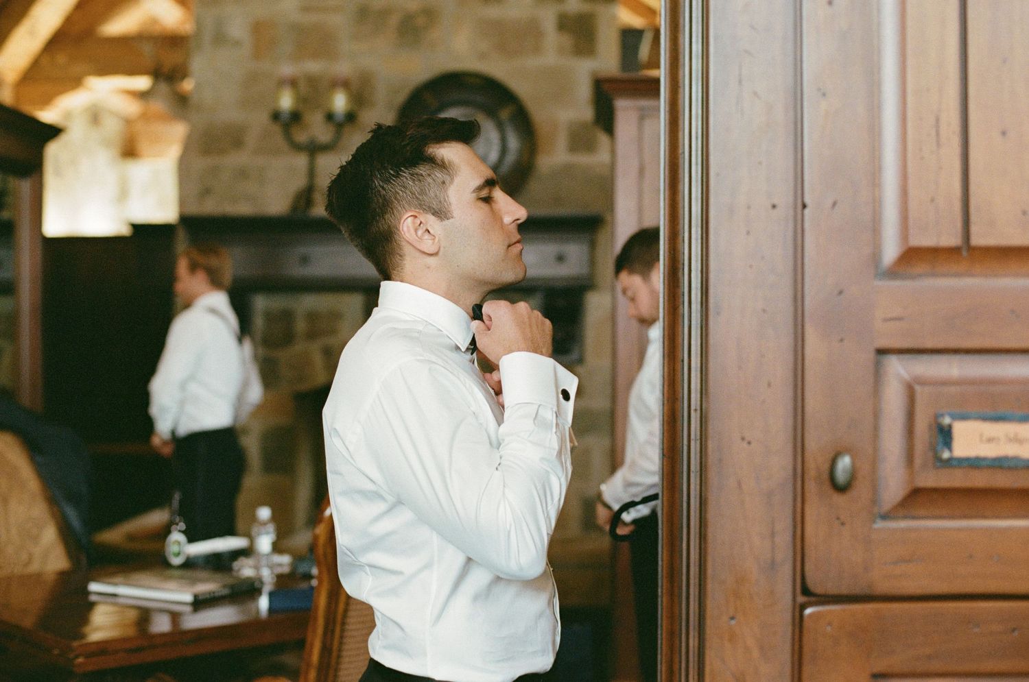 White wooden doors and stone walls create an elegant entrance to a wedding venue.