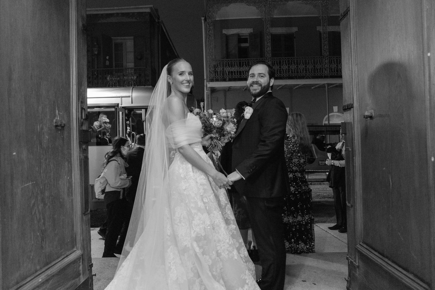 Black and white photo of a couple walking through a dimly lit hallway.