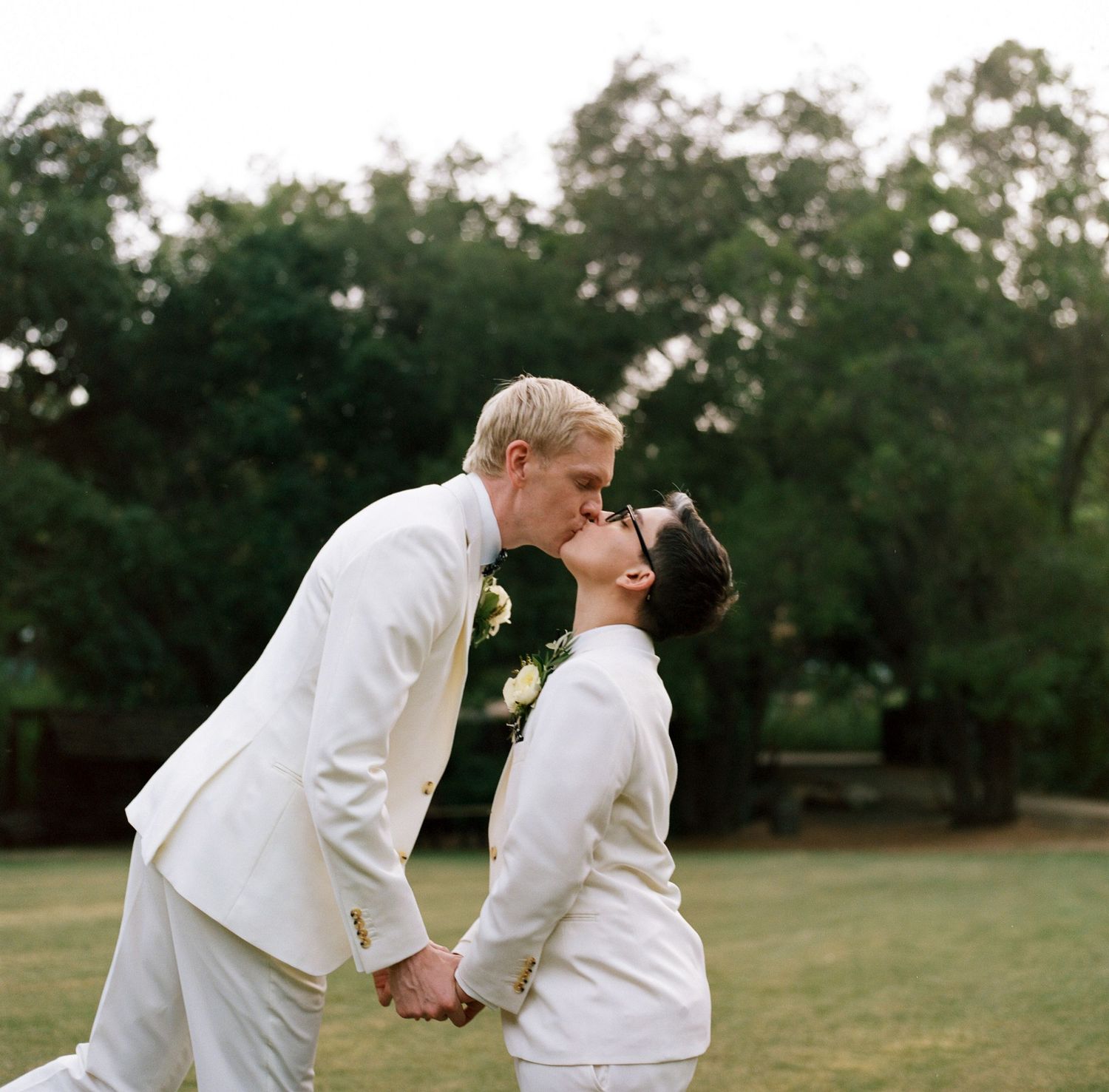 A couple shares an intimate moment while dancing together outdoors.