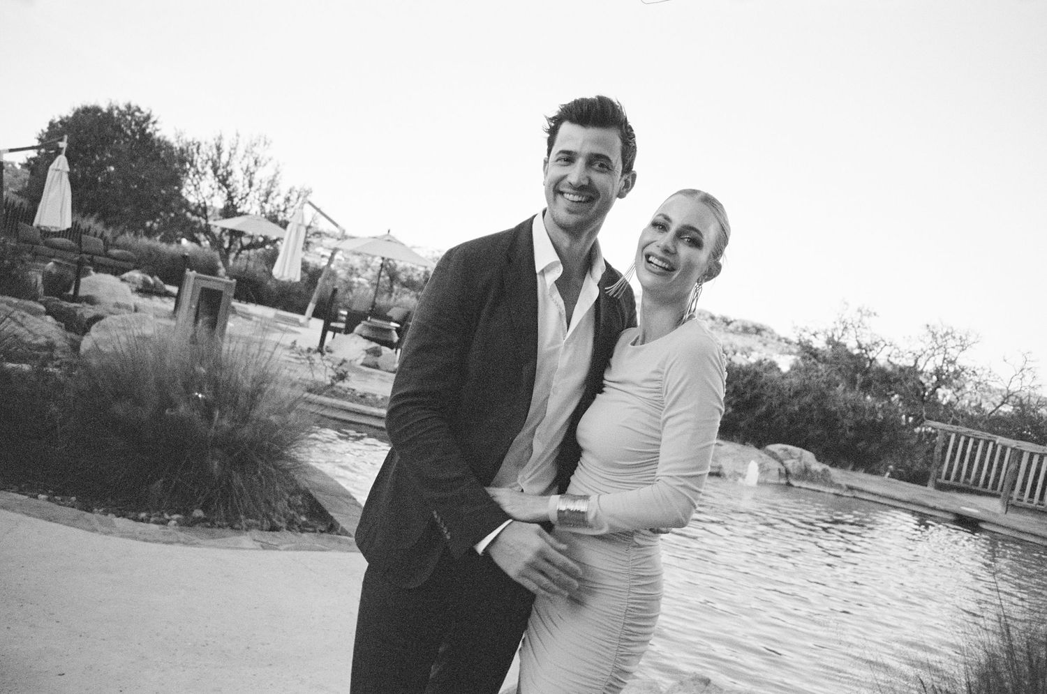 Newlyweds pose for romantic portraits near a waterfront setting.