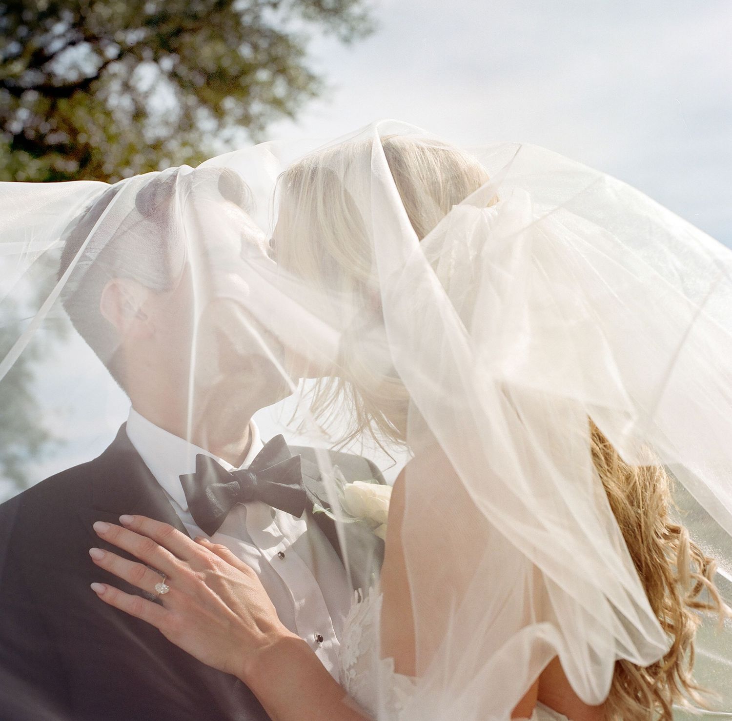 Flowing white wedding dress fabric details captured in soft natural light.