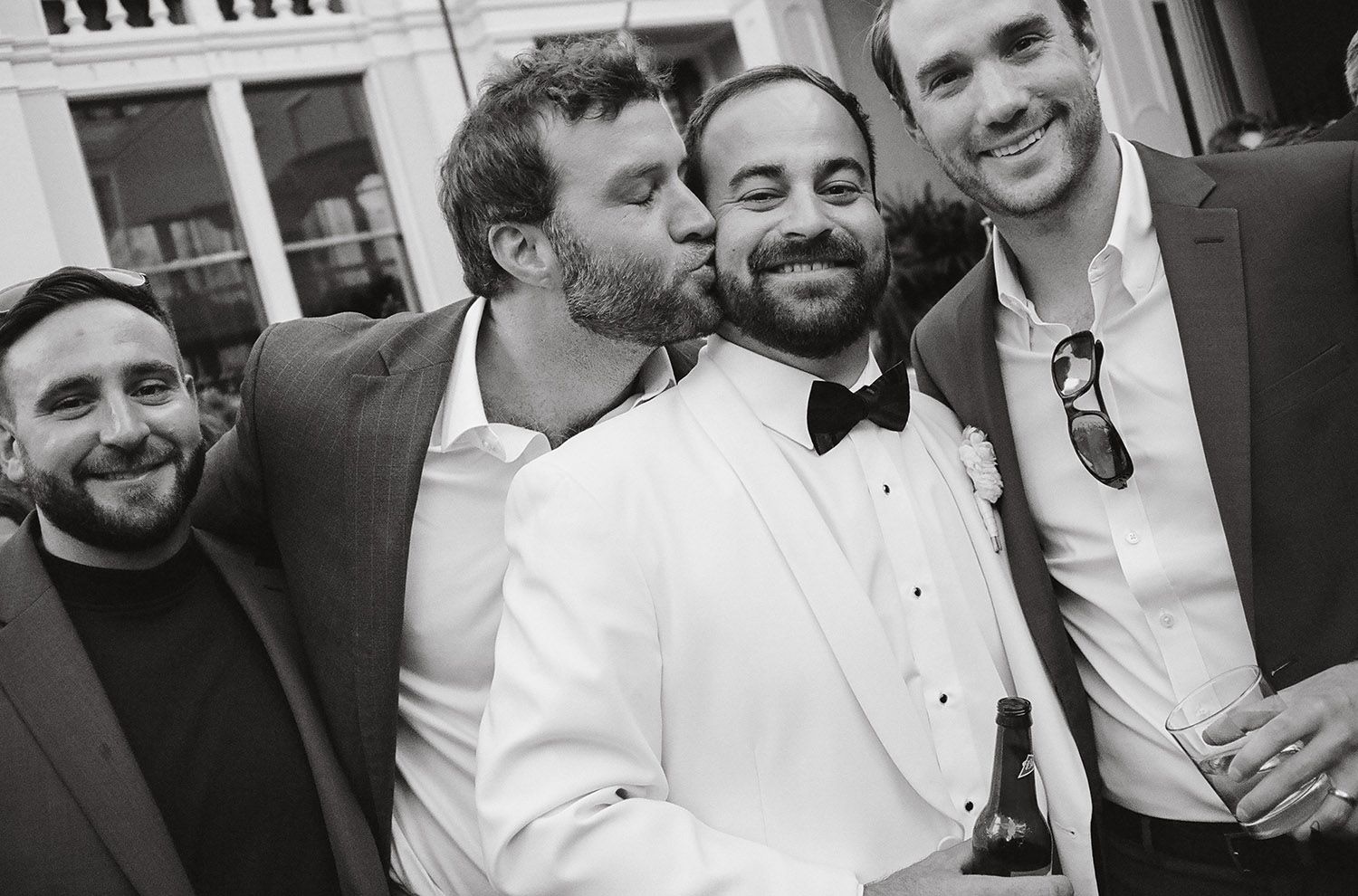 Group of men in formal attire laughing and celebrating.