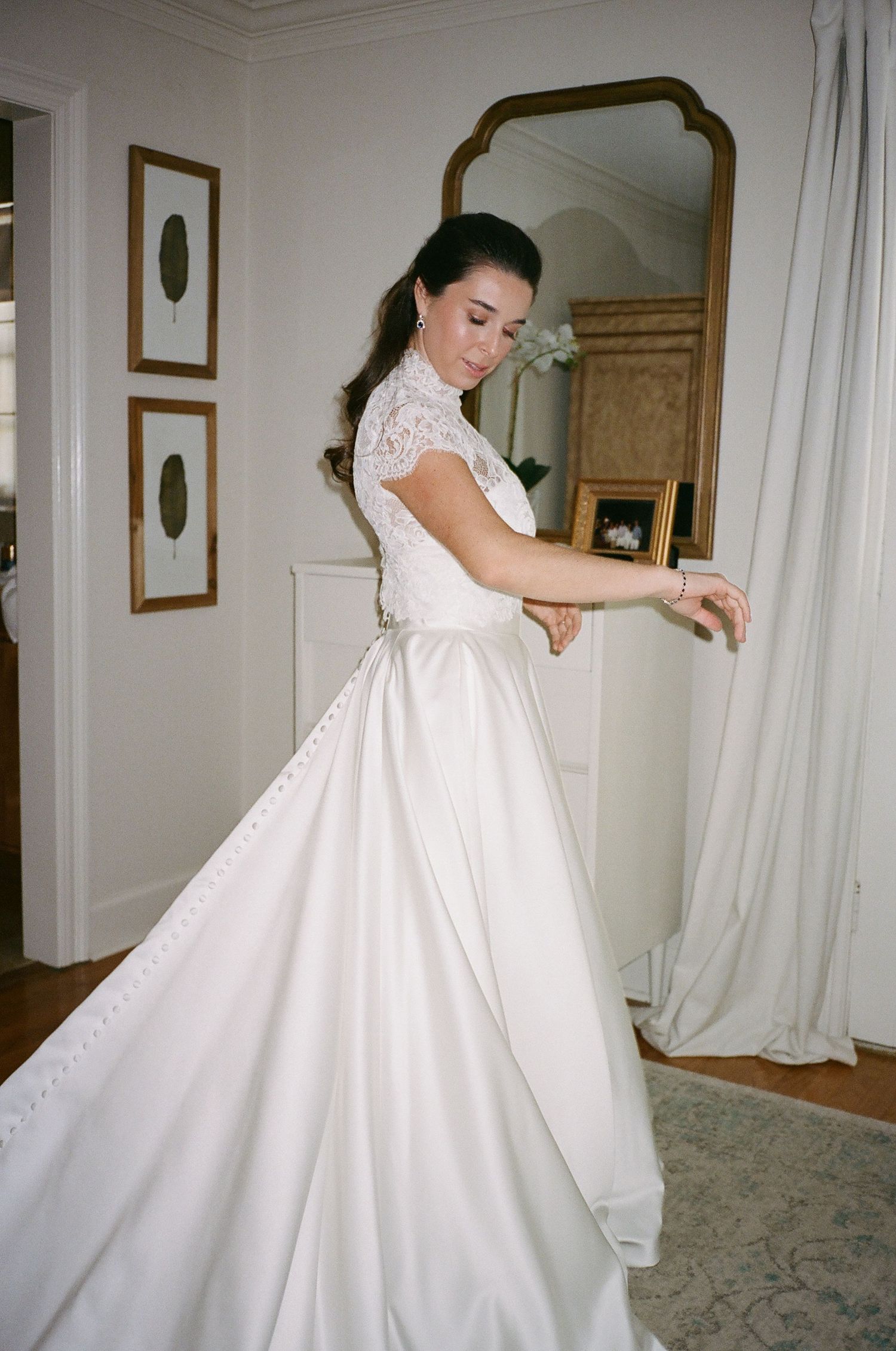 Elegant white wedding dress with lace details being showcased in a bridal suite.